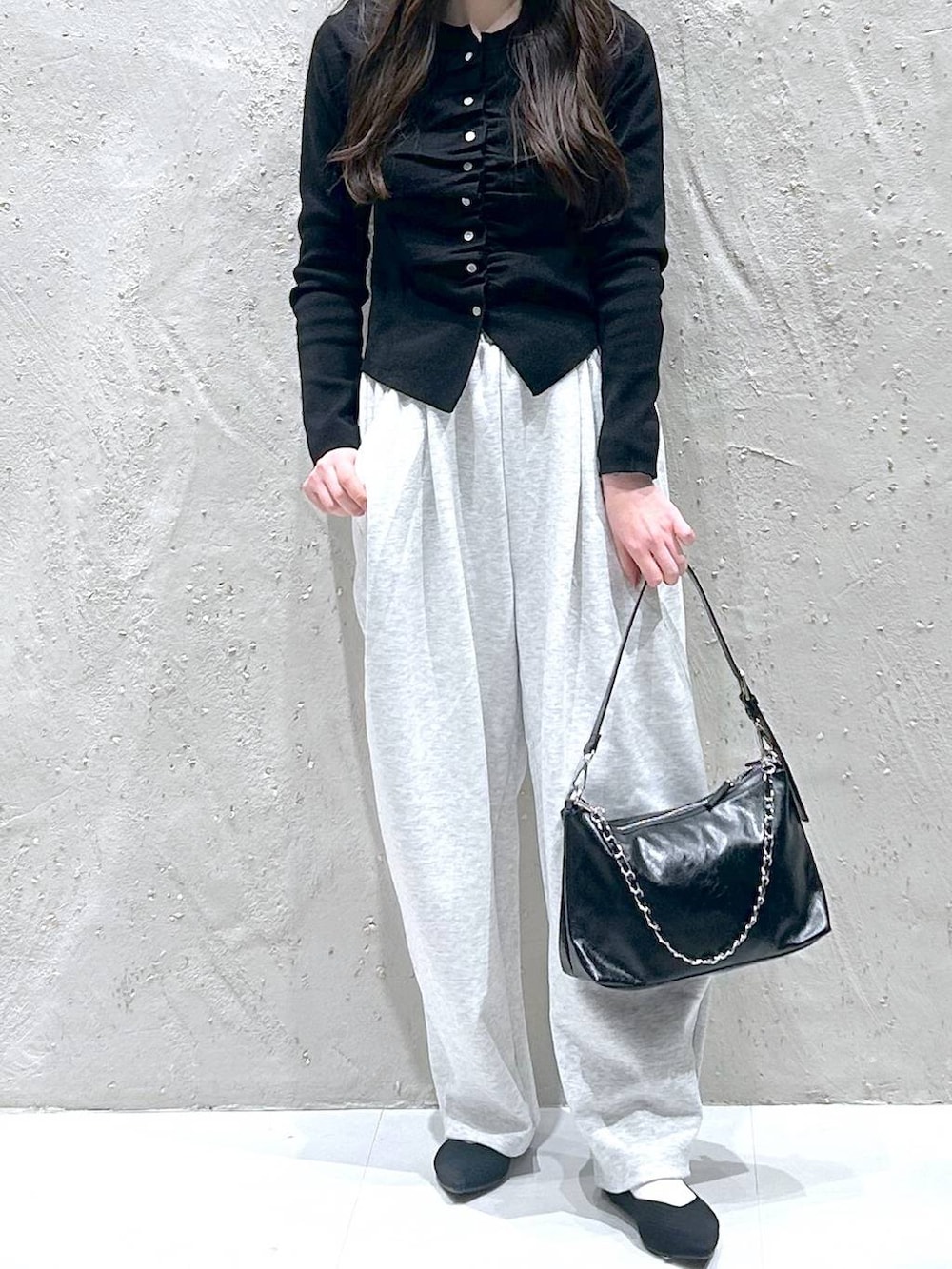 グレー系のスウェットパンツ、ブラック系のショルダーバッグ、ブラック系のパンプスを着用したレディースの春コーディネートの3枚目の写真