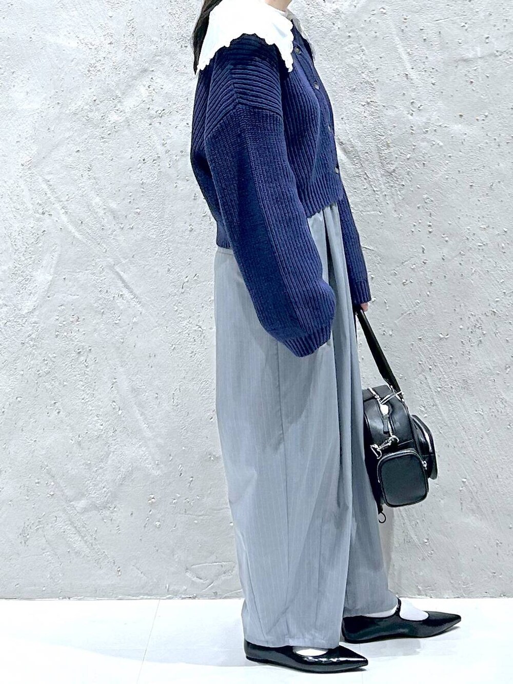 グレー系のその他パンツ、ブラック系のパンプス、ブラック系のボストンバッグを着用したレディースの冬コーディネートの4枚目の写真