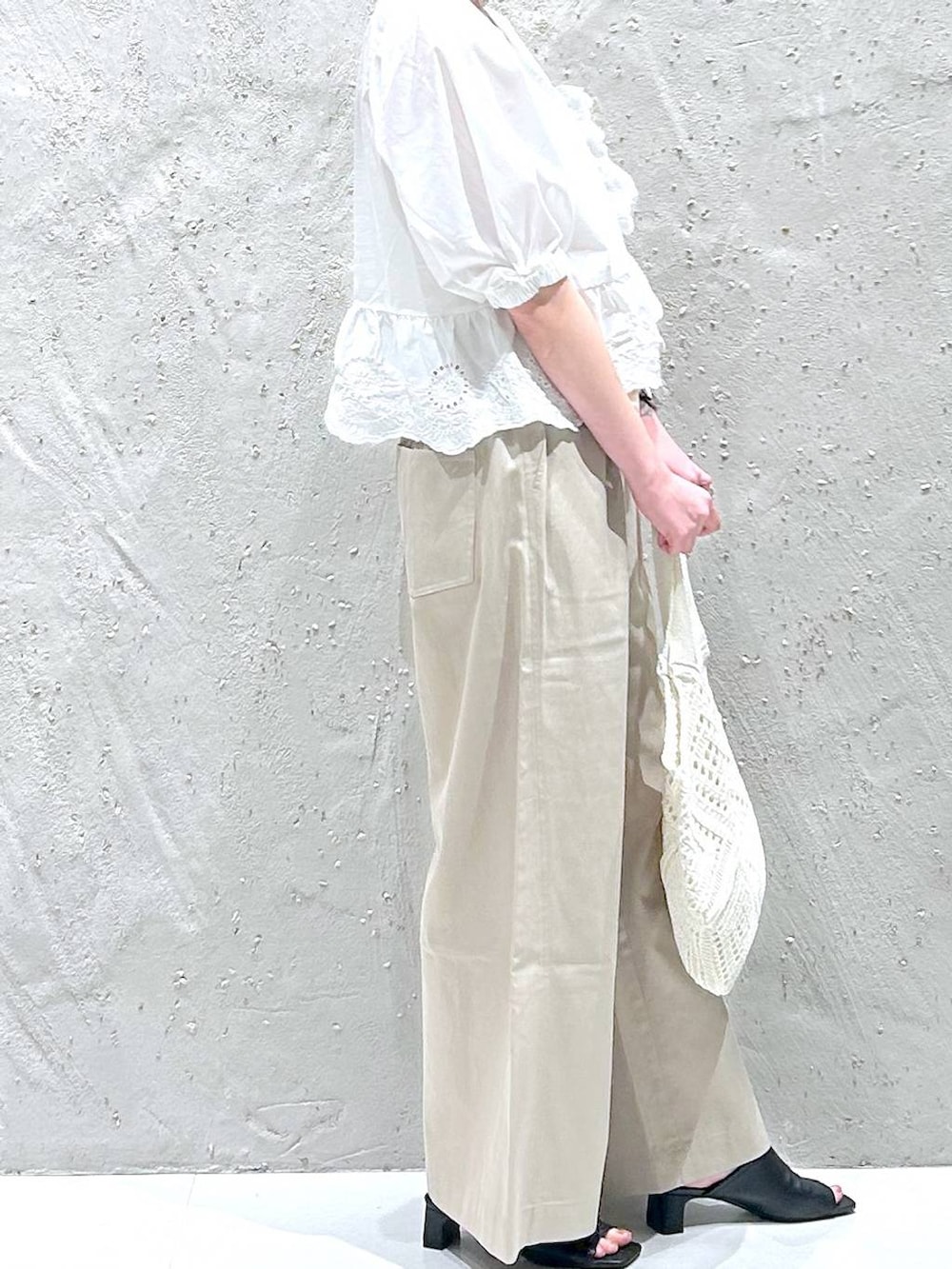 ベージュ系のデニムパンツ、ホワイト系のシャツ/ブラウス、ブラック系のサンダルを着用したレディースの夏コーディネートの4枚目の写真