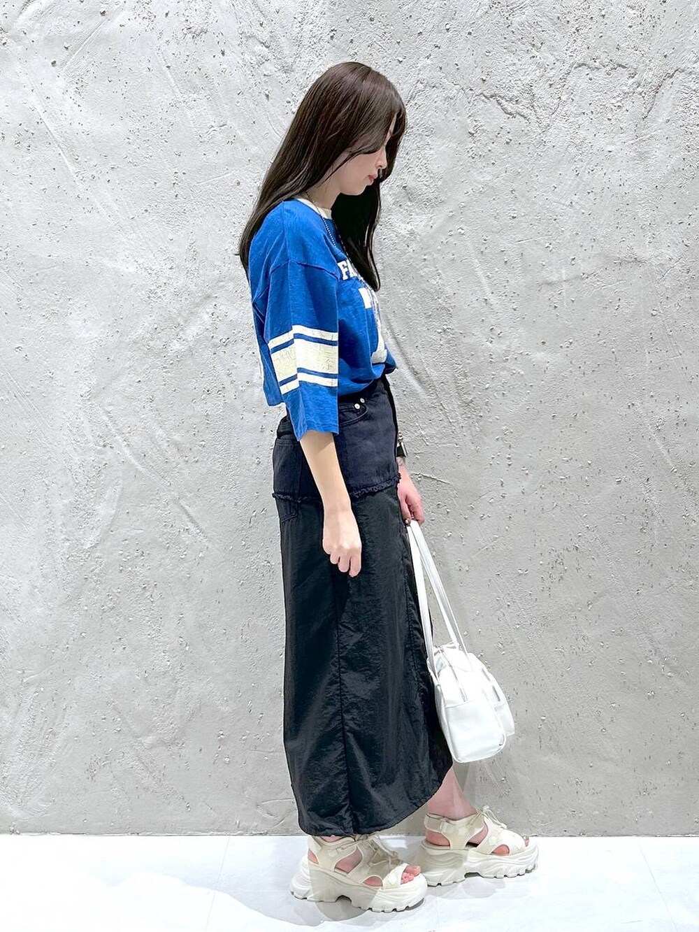 ホワイト系のサンダル、ブラック系のデニムスカート、ホワイト系のボストンバッグを着用したレディースの夏コーディネートの2枚目の写真