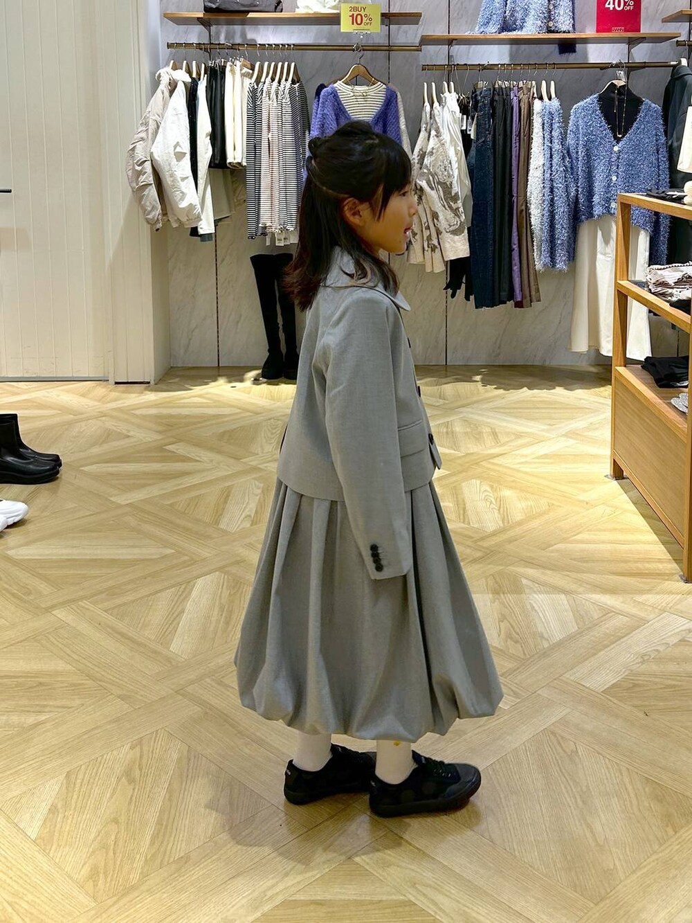 グレー系のスーツジャケット、グレー系のワンピースを着用したキッズの冬コーディネートの2枚目の写真