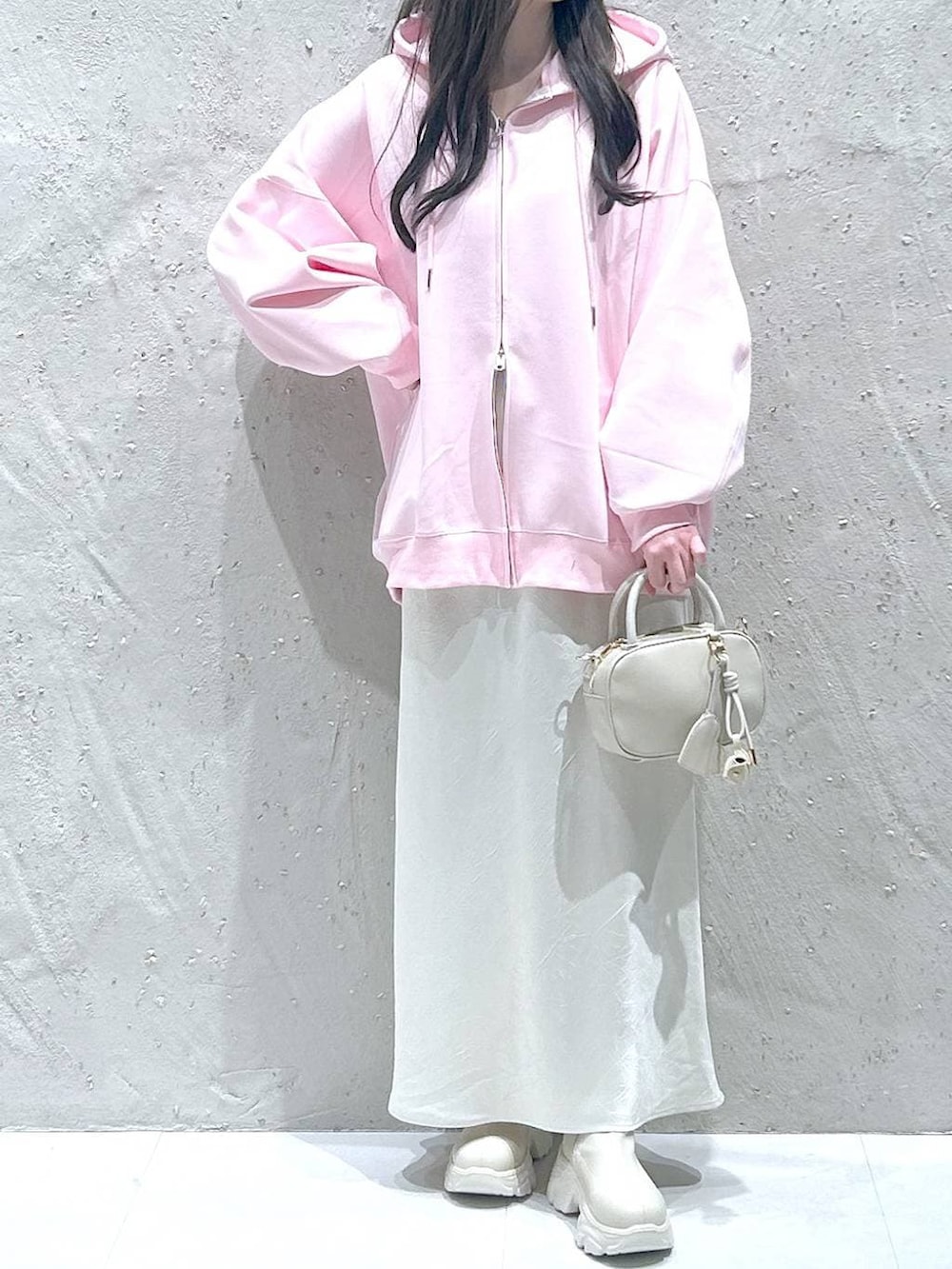 ホワイト系のブーツ、ブラック系のスカート、ピンク系のパーカーを着用したレディースの春コーディネートの3枚目の写真