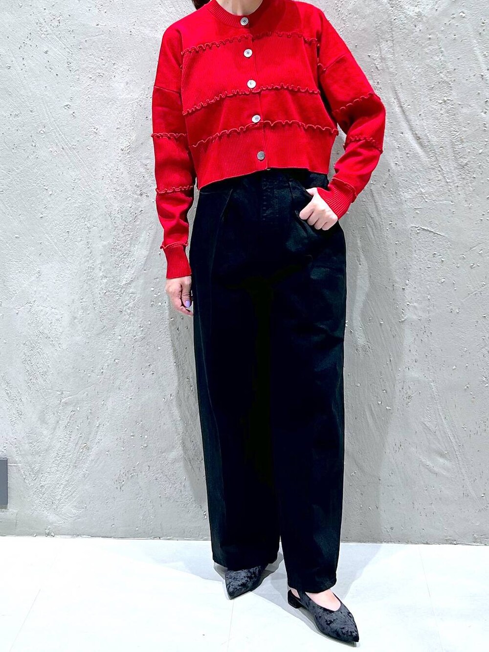 ブラック系のデニムパンツ、ブラック系のパンプス、レッド系のニット/セーターを着用したレディースの秋コーディネートの2枚目の写真