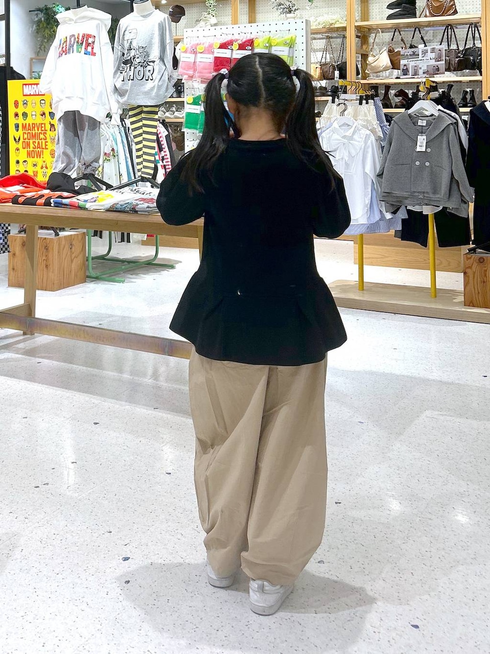 ベージュ系のその他パンツ、ブラック系のカーディガン/ボレロを着用したキッズの春コーディネートの3枚目の写真