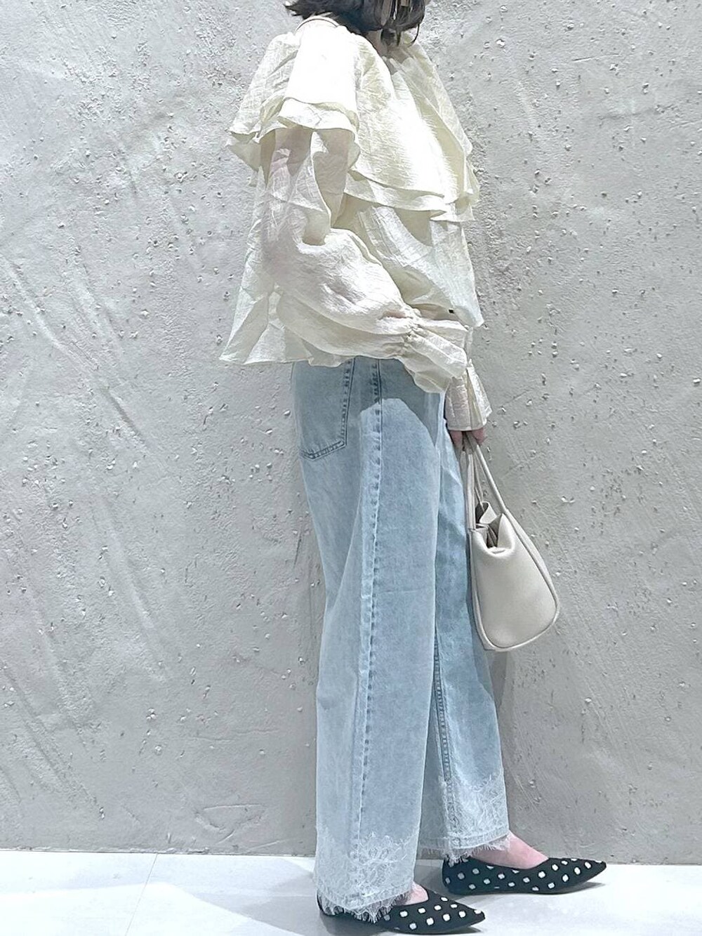 ホワイト系のショルダーバッグ、ブルー系のデニムパンツ、その他のパンプスを着用したレディースの春コーディネートの4枚目の写真