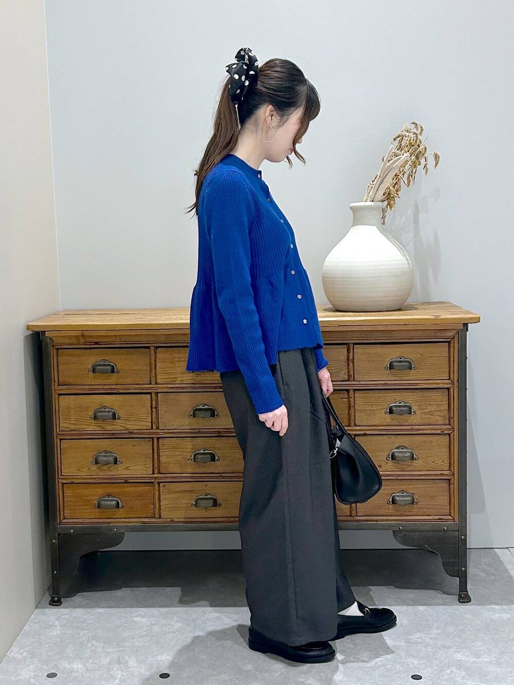 ブラック系のショルダーバッグ、グレー系のその他パンツ、ブラック系のローファーを着用したレディースの秋コーディネートの2枚目の写真