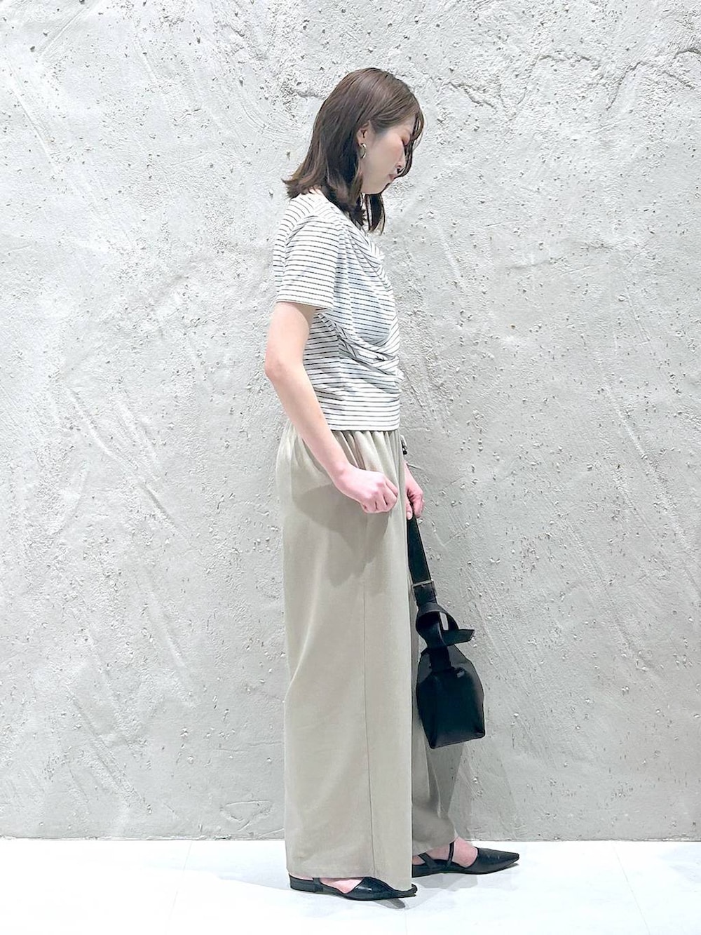ベージュ系のその他パンツ、ホワイト系のTシャツ/カットソー、ブラック系のサンダルを着用したレディースの夏コーディネートの2枚目の写真