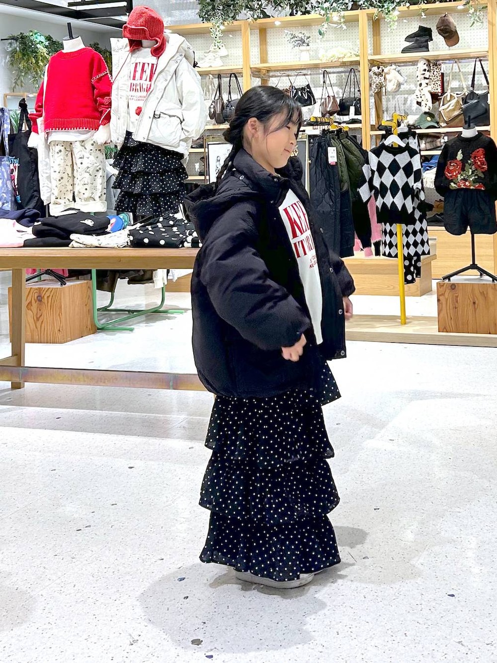 ブラック系のダウンジャケット/コート、ホワイト系のスウェット、ブラック系のスカートを着用したレディースの秋コーディネートの2枚目の写真