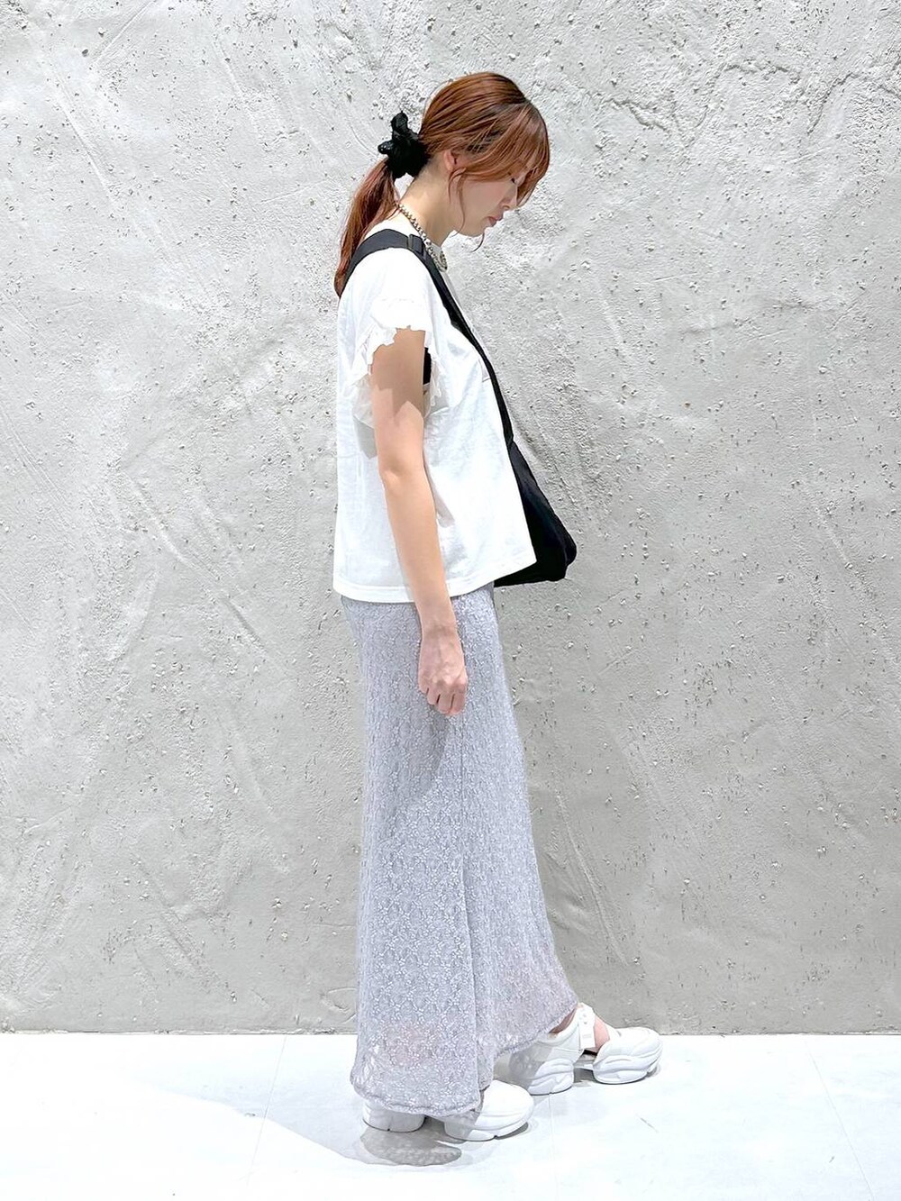 ホワイト系のサンダル、ホワイト系のTシャツ/カットソー、ブラック系のショルダーバッグを着用したレディースの夏コーディネートの3枚目の写真