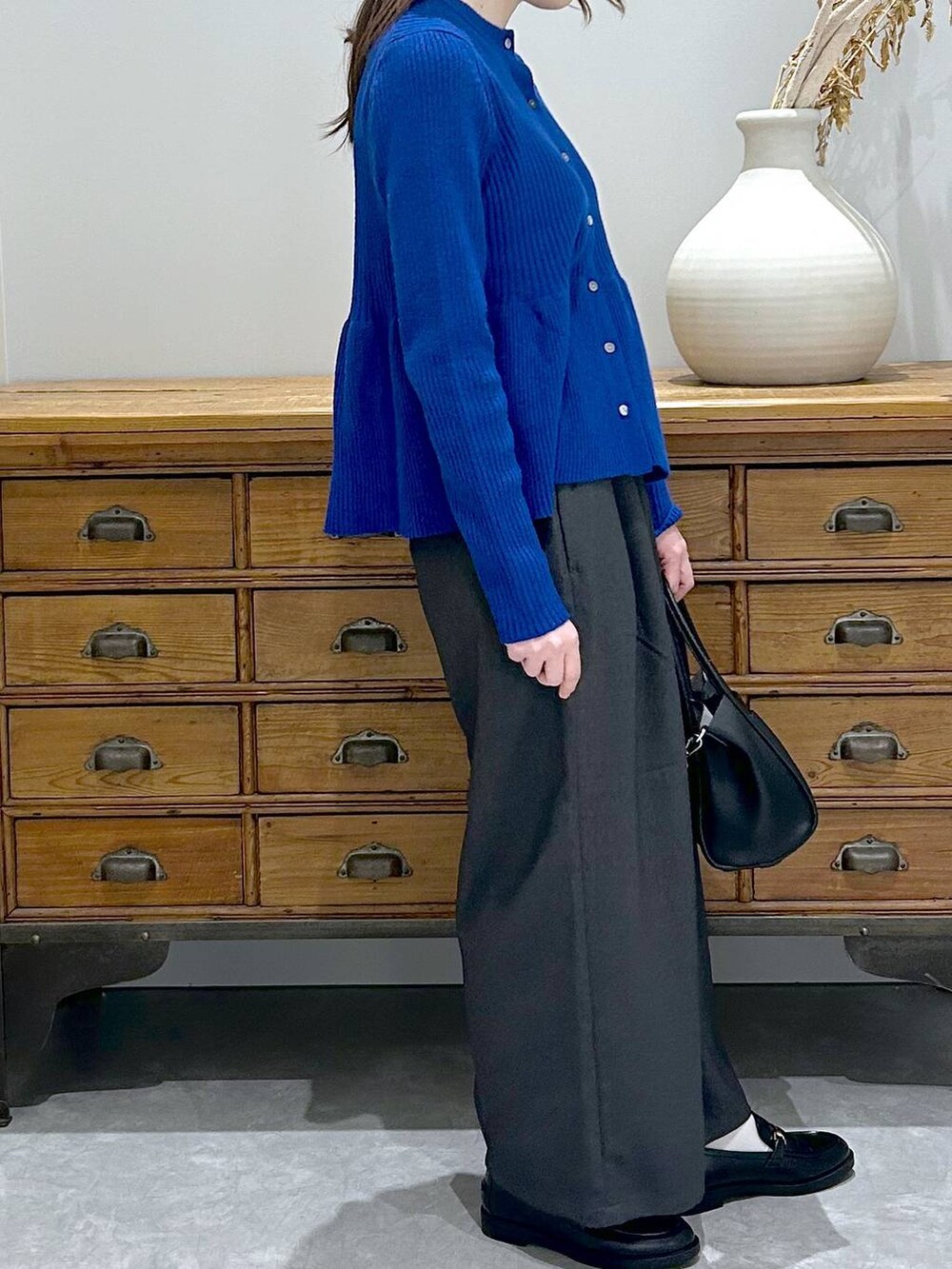 ブラック系のショルダーバッグ、グレー系のその他パンツ、ブラック系のローファーを着用したレディースの秋コーディネートの4枚目の写真