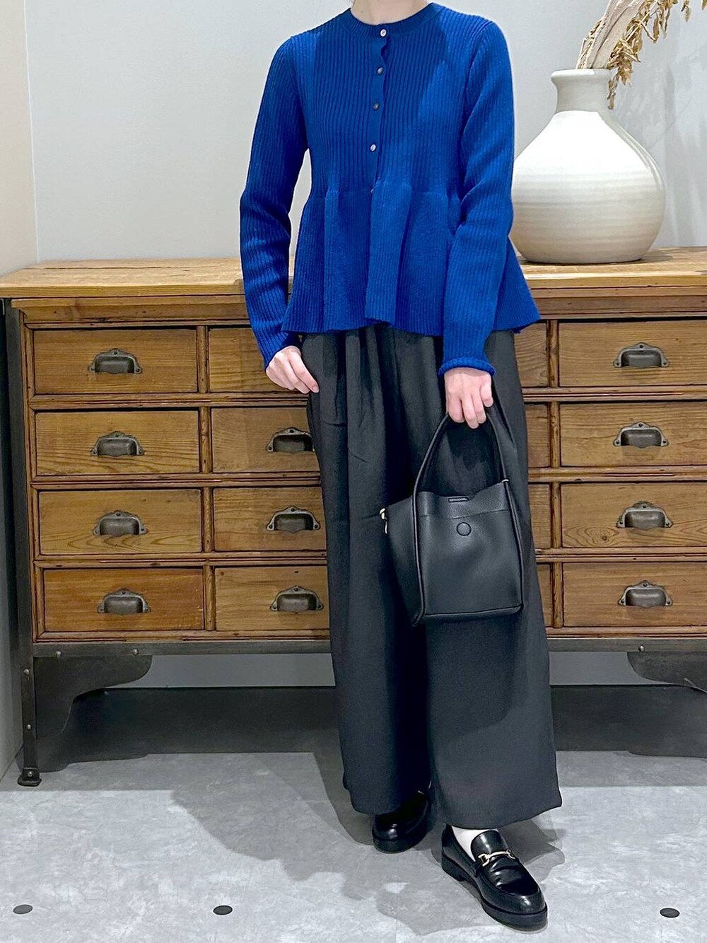 ブラック系のショルダーバッグ、グレー系のその他パンツ、ブラック系のローファーを着用したレディースの秋コーディネートの3枚目の写真