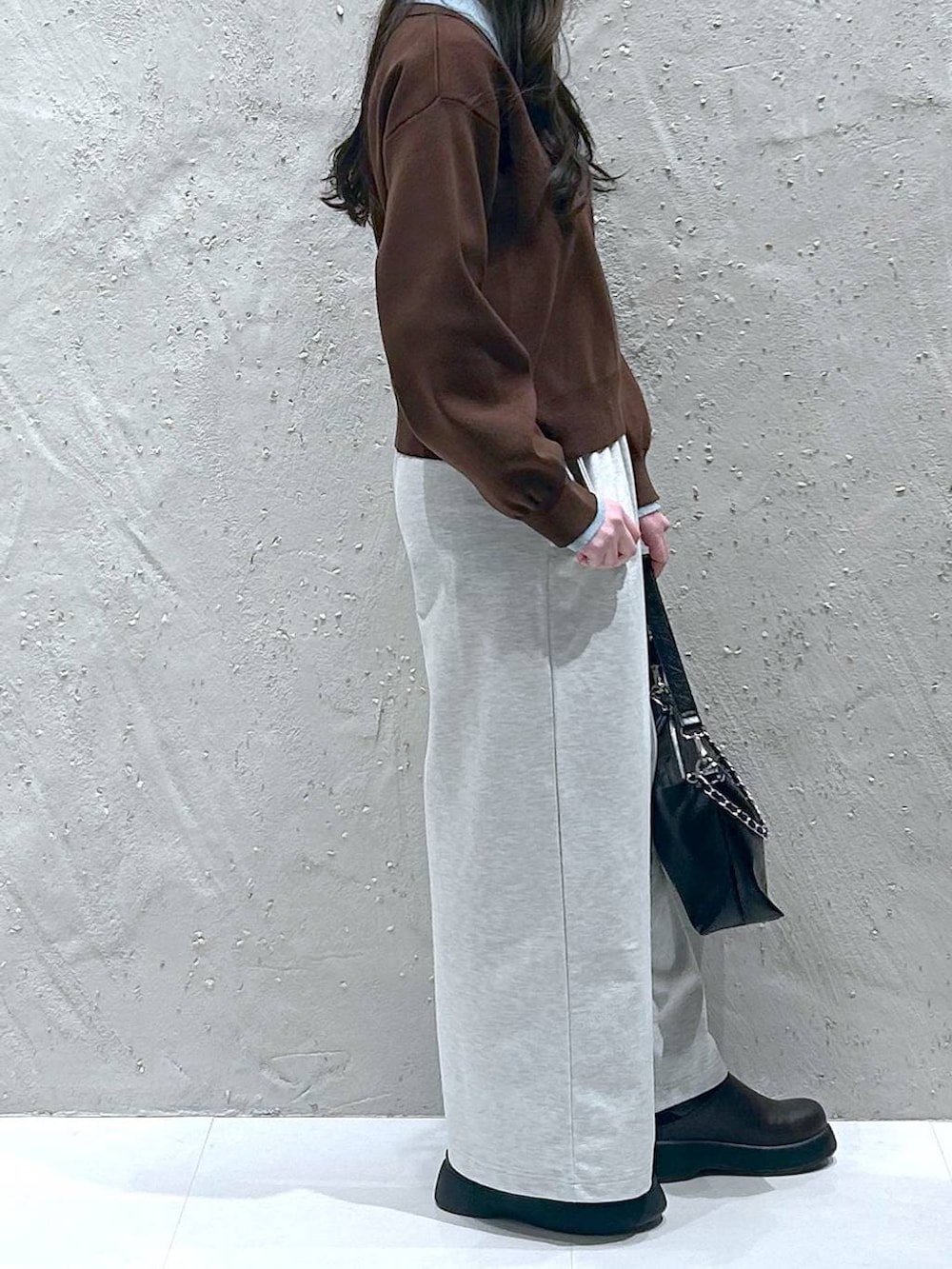 ブラック系のショルダーバッグ、ブラウン系のニット/セーター、ブラウン系のサンダルを着用したレディースの春コーディネートの4枚目の写真