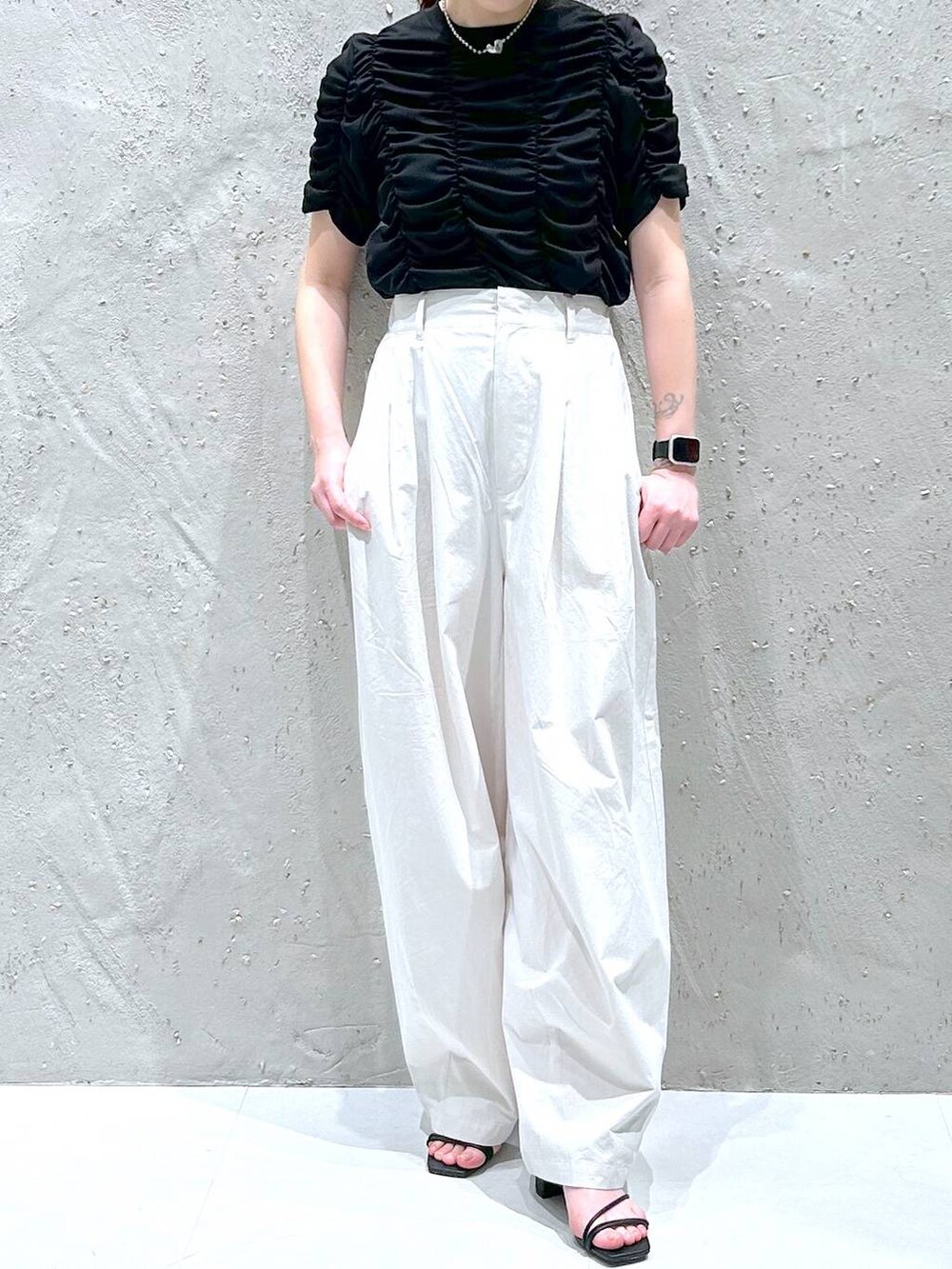 ブラック系のサンダル、グレー系のその他パンツ、ブラック系のTシャツ/カットソーを着用したレディースの春コーディネートの2枚目の写真