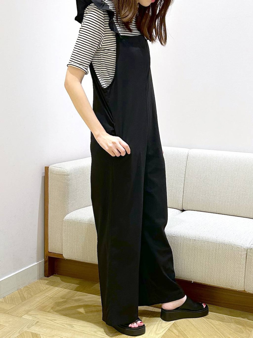 ホワイト系のショルダーバッグ、ブラック系のサンダル、ホワイト系のTシャツ/カットソーを着用したレディースの夏コーディネートの4枚目の写真