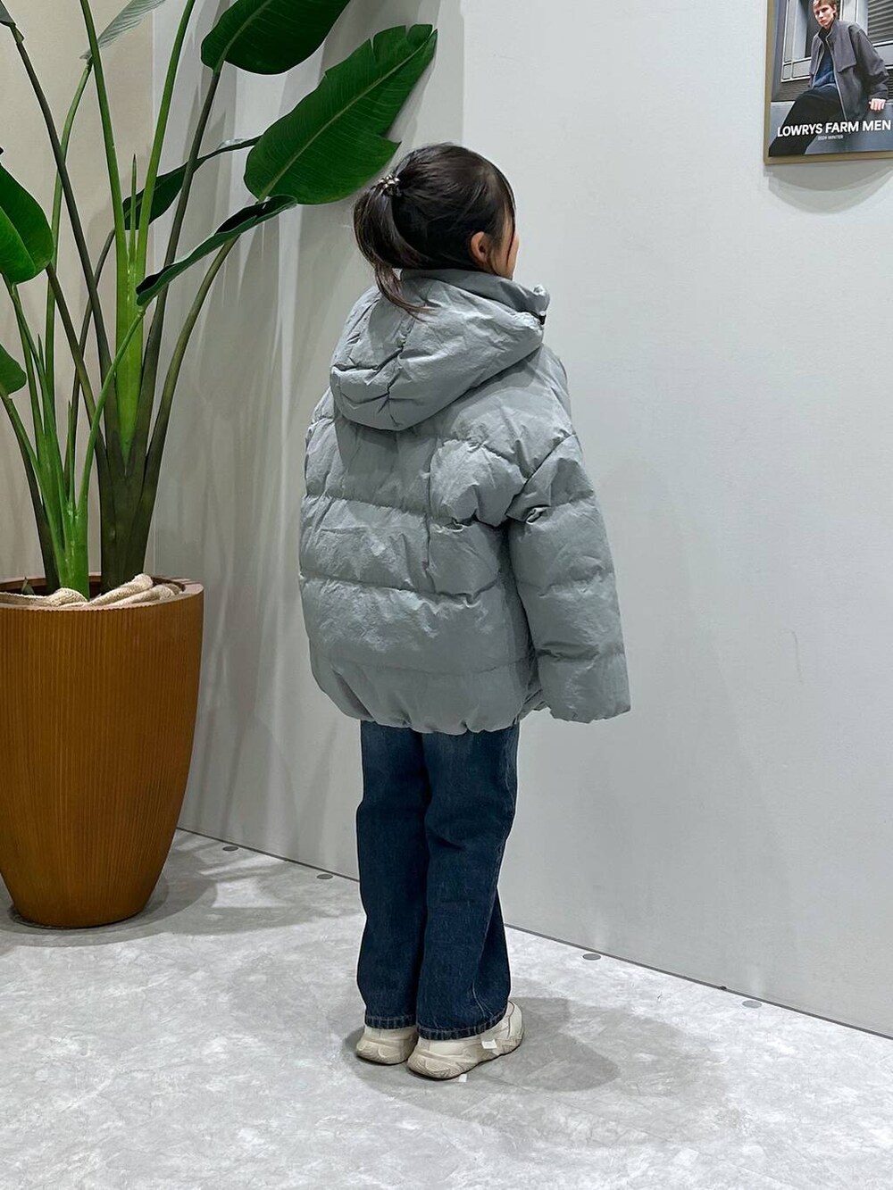 ブルー系のダウンジャケット/コート、ブルー系のデニムパンツ、ブルー系のニット/セーターを着用したキッズの冬コーディネートの3枚目の写真