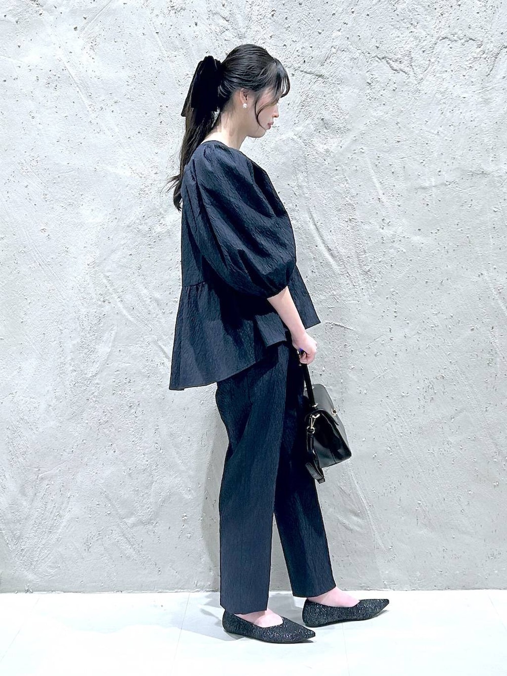 ブラック系のボストンバッグ、ブルー系のシャツ/ブラウス、ブルー系のその他パンツを着用したレディースの冬コーディネートの2枚目の写真