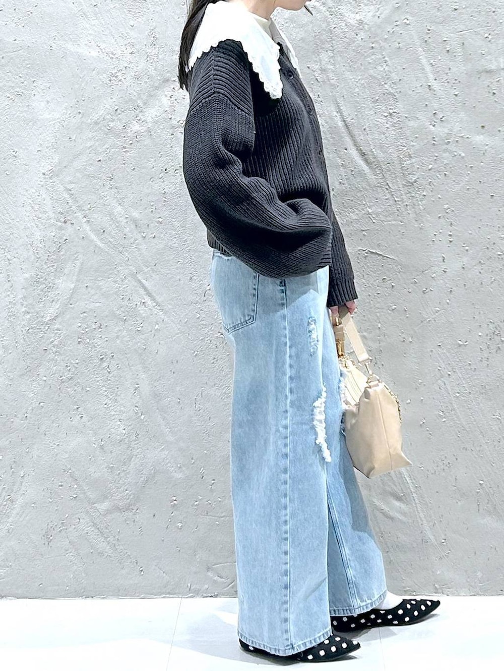 ブルー系のデニムパンツ、ベージュ系のショルダーバッグ、ホワイト系のTシャツ/カットソーを着用したレディースの冬コーディネートの4枚目の写真