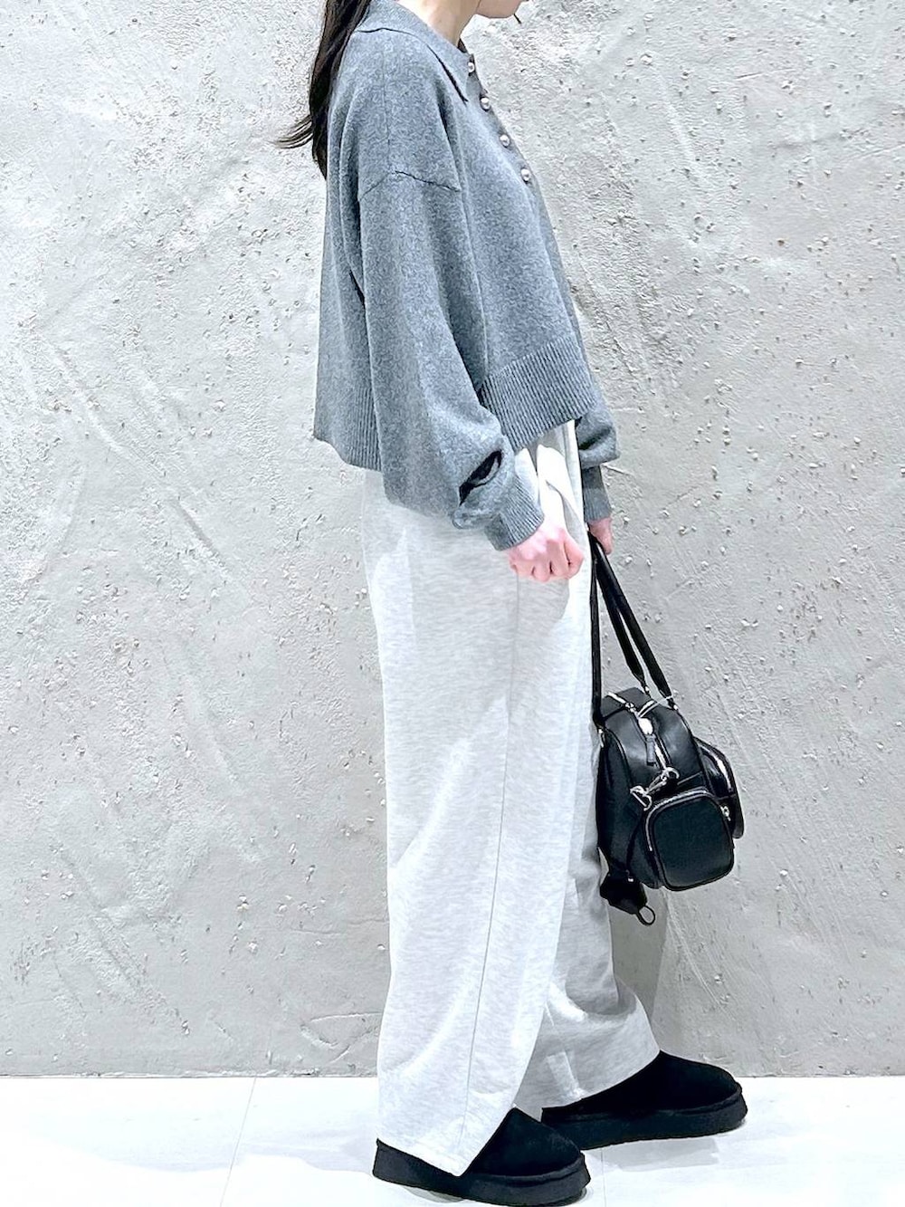 グレー系のスウェットパンツ、ブラック系のブーツ、ブラック系のボストンバッグを着用したレディースの冬コーディネートの4枚目の写真