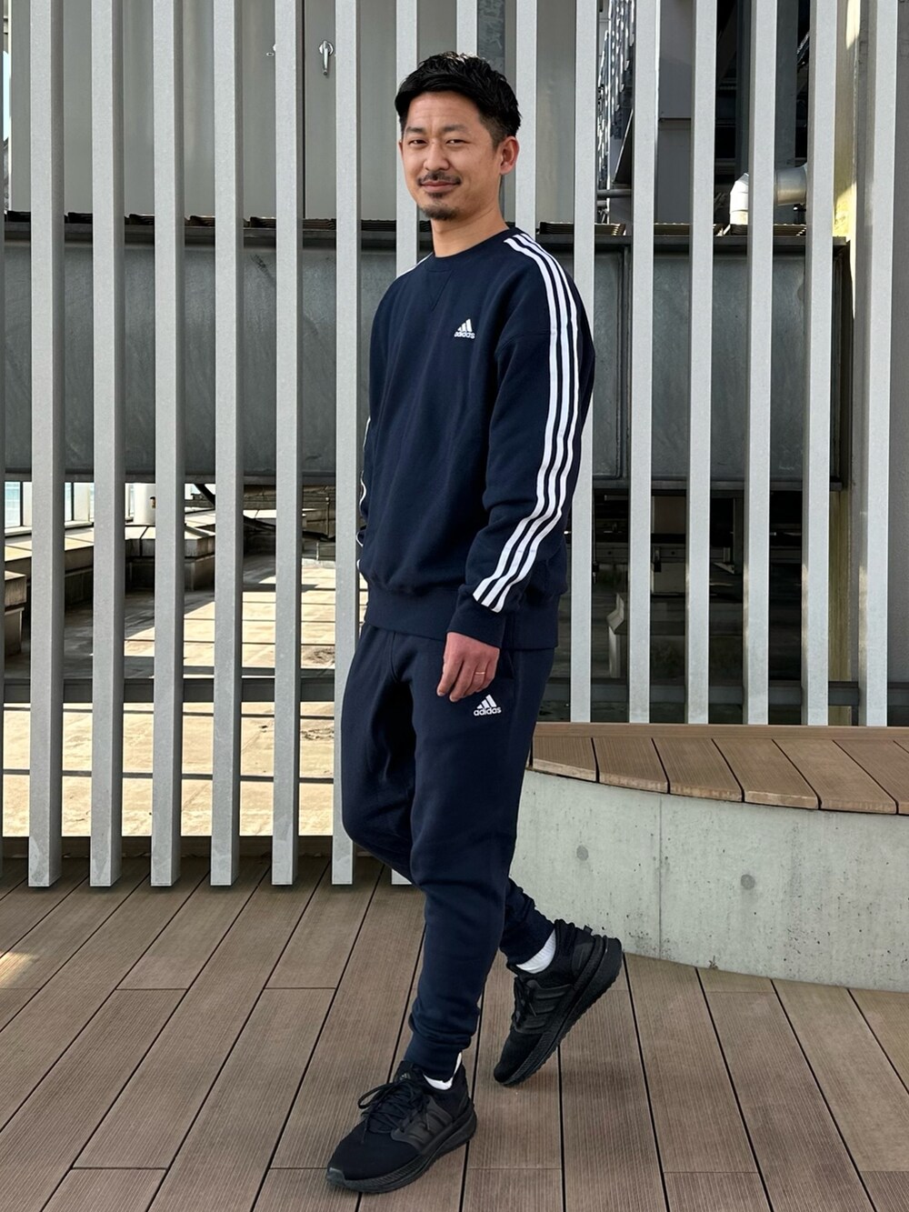 ブラック系のスニーカー、ブルー系のスウェットパンツ、ブルー系のスウェットを着用したメンズの冬コーディネートの2枚目の写真