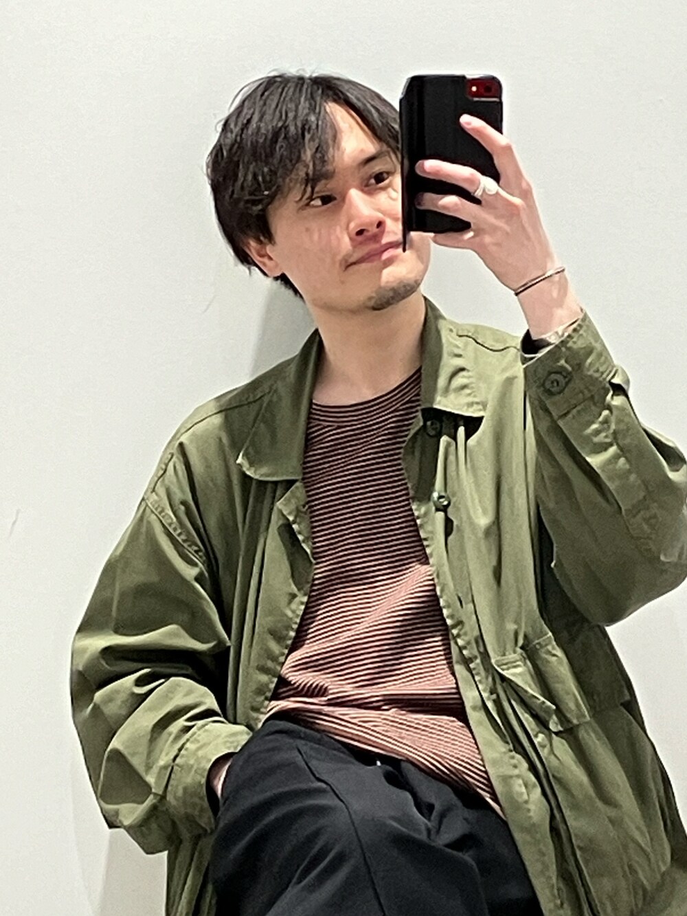 ブラウン系のTシャツ/カットソー、グリーン系のミリタリージャケット、ブラック系のパンツを着用したメンズの春コーディネートの3枚目の写真