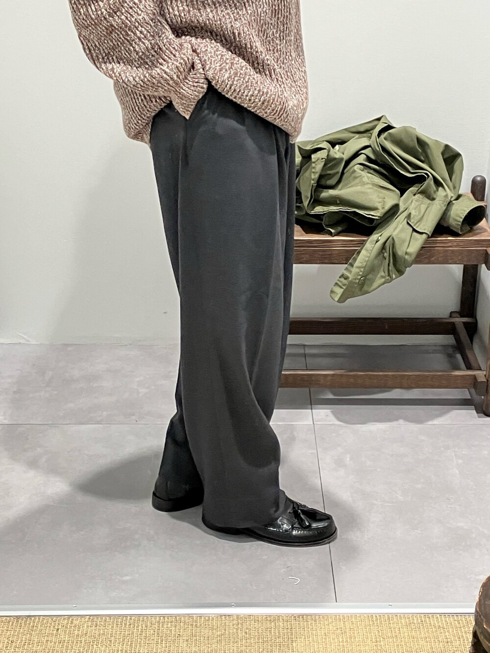 グリーン系のミリタリージャケット、ブラウン系のニット/セーター、グレー系のスラックスを着用したメンズの冬コーディネートの3枚目の写真