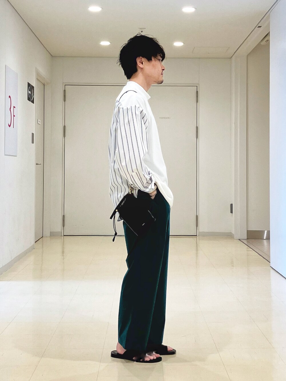 ホワイト系のTシャツ/カットソー、グリーン系のその他パンツ、ブラック系のサンダルを着用したメンズの春コーディネートの3枚目の写真