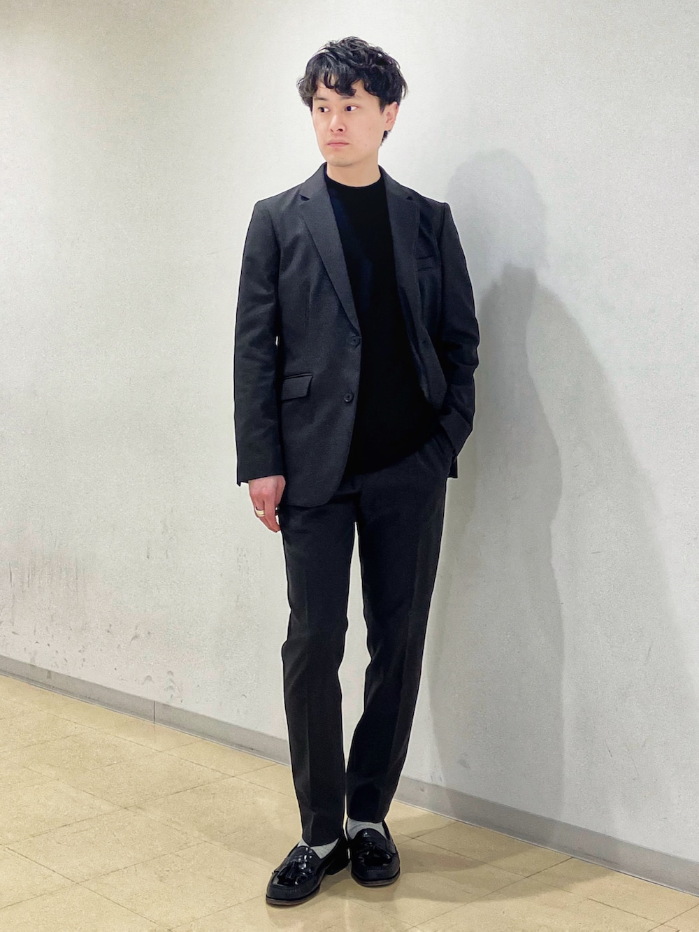 ブラウン系のダウンジャケット/コート、グレー系のセットアップ、ブラック系のニット/セーターを着用したメンズの冬コーディネートの5枚目の写真