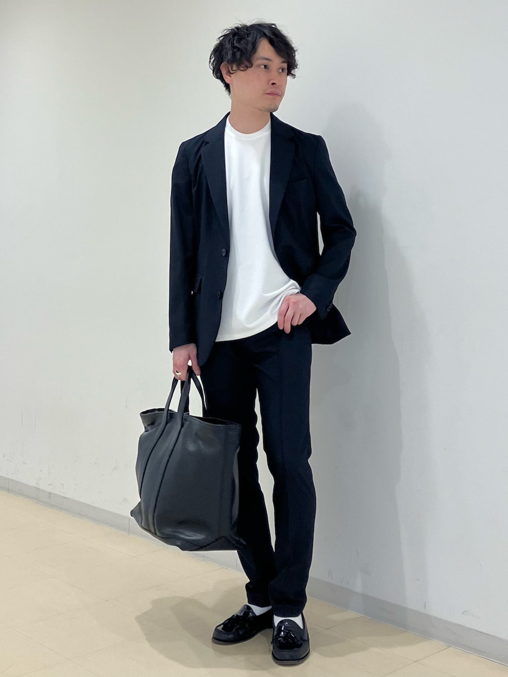 ホワイト系のTシャツ/カットソー、ブルー系のスーツジャケット、ブラック系のトートバッグを着用したメンズの夏コーディネートの2枚目の写真