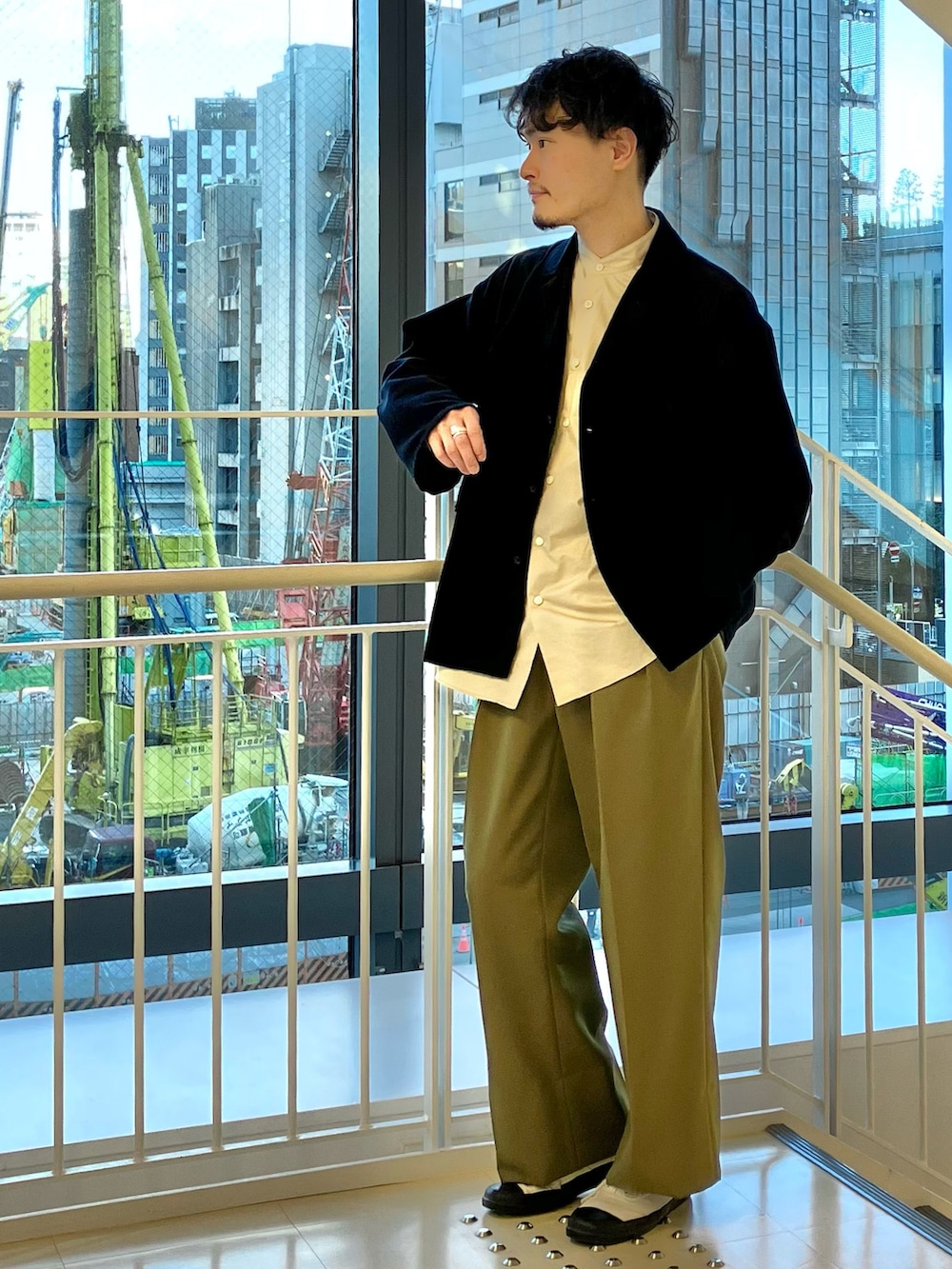 ブラック系のジャケット/アウター、ベージュ系のシャツ/ブラウス、グリーン系のパンツを着用したメンズの冬コーディネートの2枚目の写真