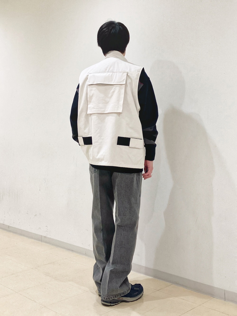ベージュ系のベスト、ブラック系のニット/セーター、ブラック系のデニムパンツを着用したメンズの秋コーディネートの3枚目の写真