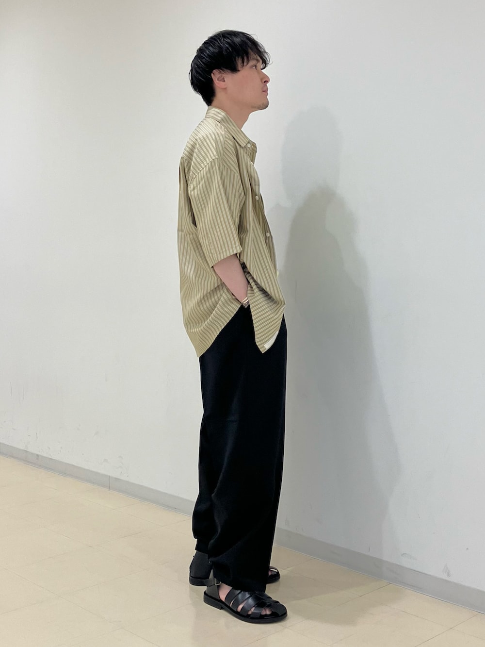 ベージュ系のシャツ/ブラウス、イエロー系のTシャツ/カットソー、ブラック系のスラックスを着用したメンズの春コーディネートの2枚目の写真