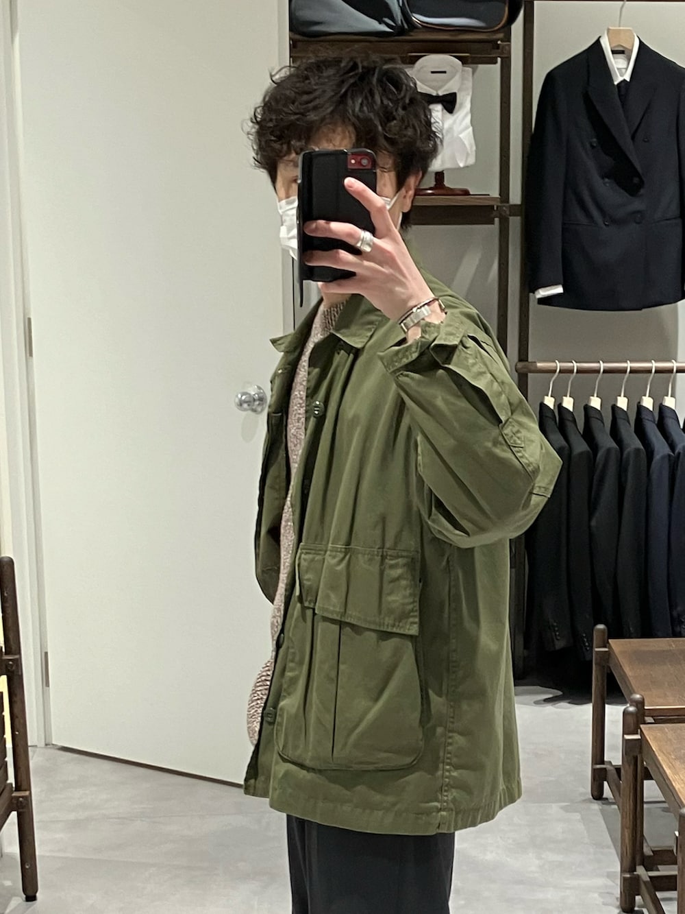 グリーン系のミリタリージャケット、ブラウン系のニット/セーター、グレー系のスラックスを着用したメンズの冬コーディネートの2枚目の写真