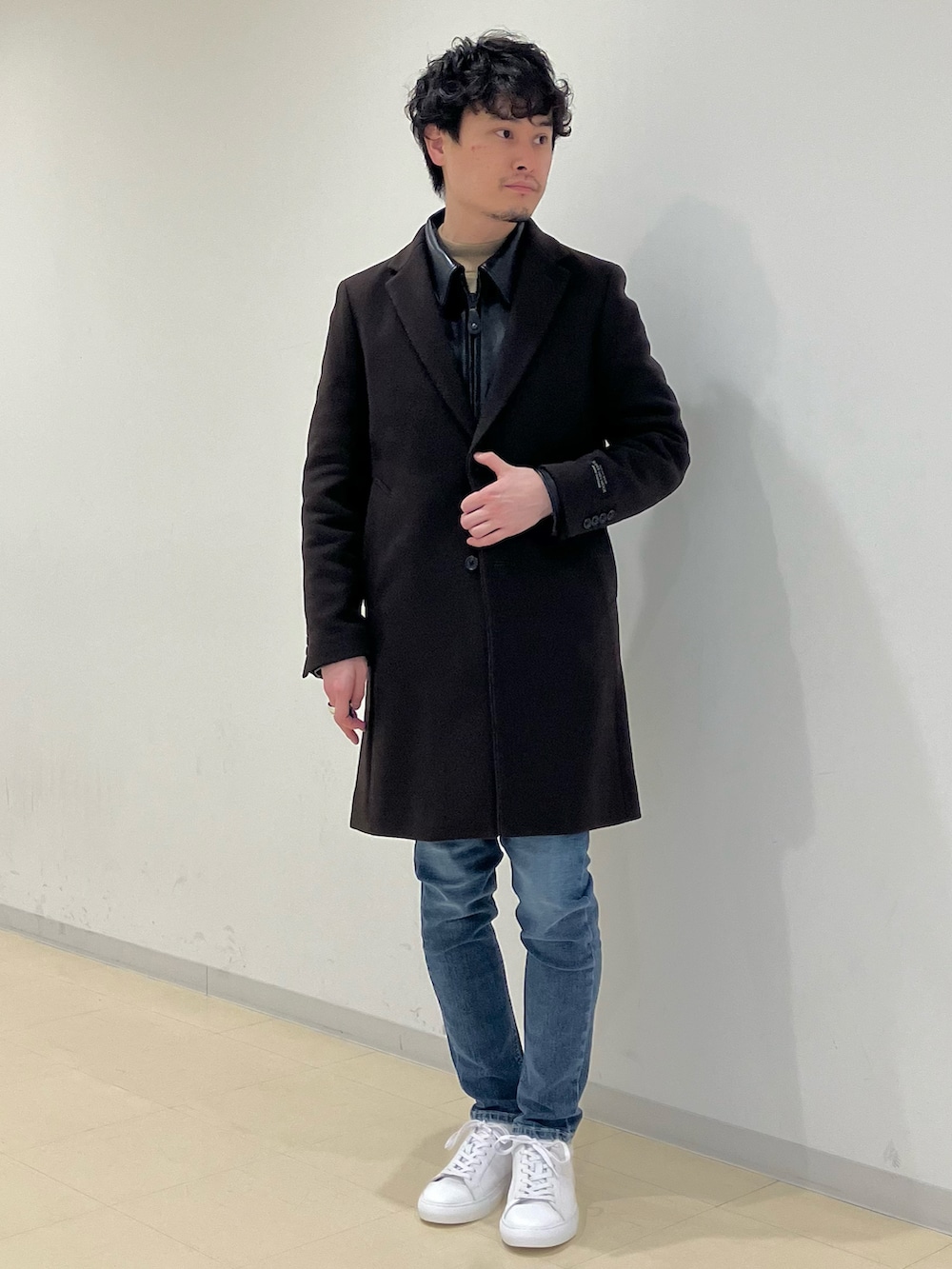 ブラウン系のチェスターコート、ブラック系のライダースジャケット、ブルー系のデニムパンツを着用したメンズの冬コーディネートの2枚目の写真