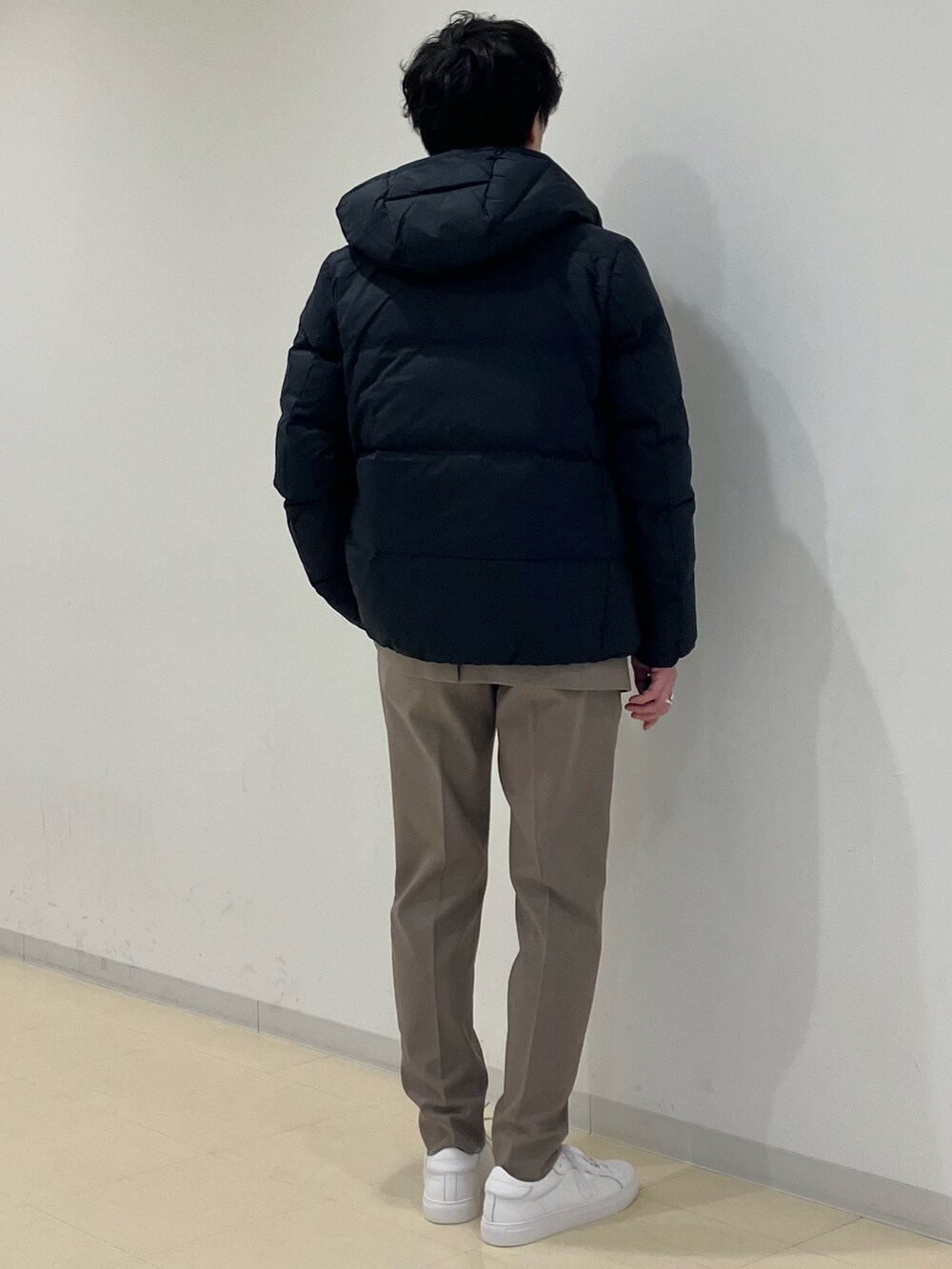 グレー系のニット/セーター、ブラック系のダウンジャケット/コート、ベージュ系のセットアップを着用したメンズの冬コーディネートの3枚目の写真