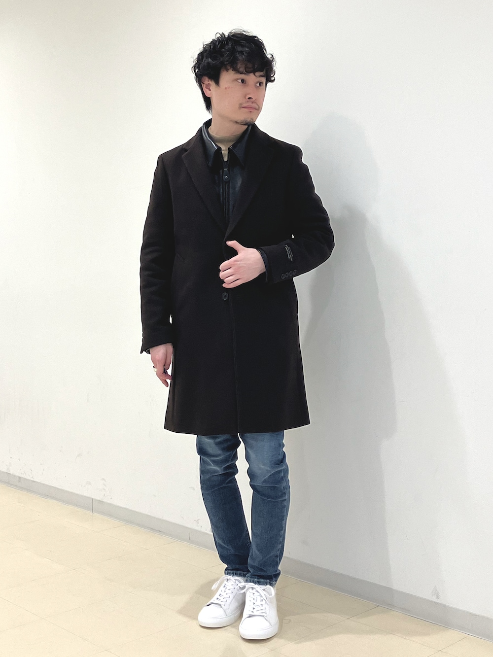 ブラック系のライダースジャケット、ベージュ系のニット/セーター、ブルー系のデニムパンツを着用したメンズの冬コーディネートの3枚目の写真