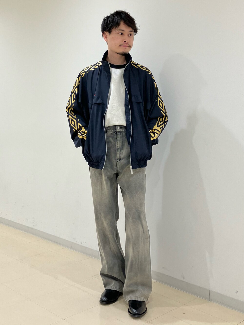 ブルー系のブルゾン、ブラック系のデニムパンツ、ブラック系のブーツを着用したメンズの春コーディネートの4枚目の写真