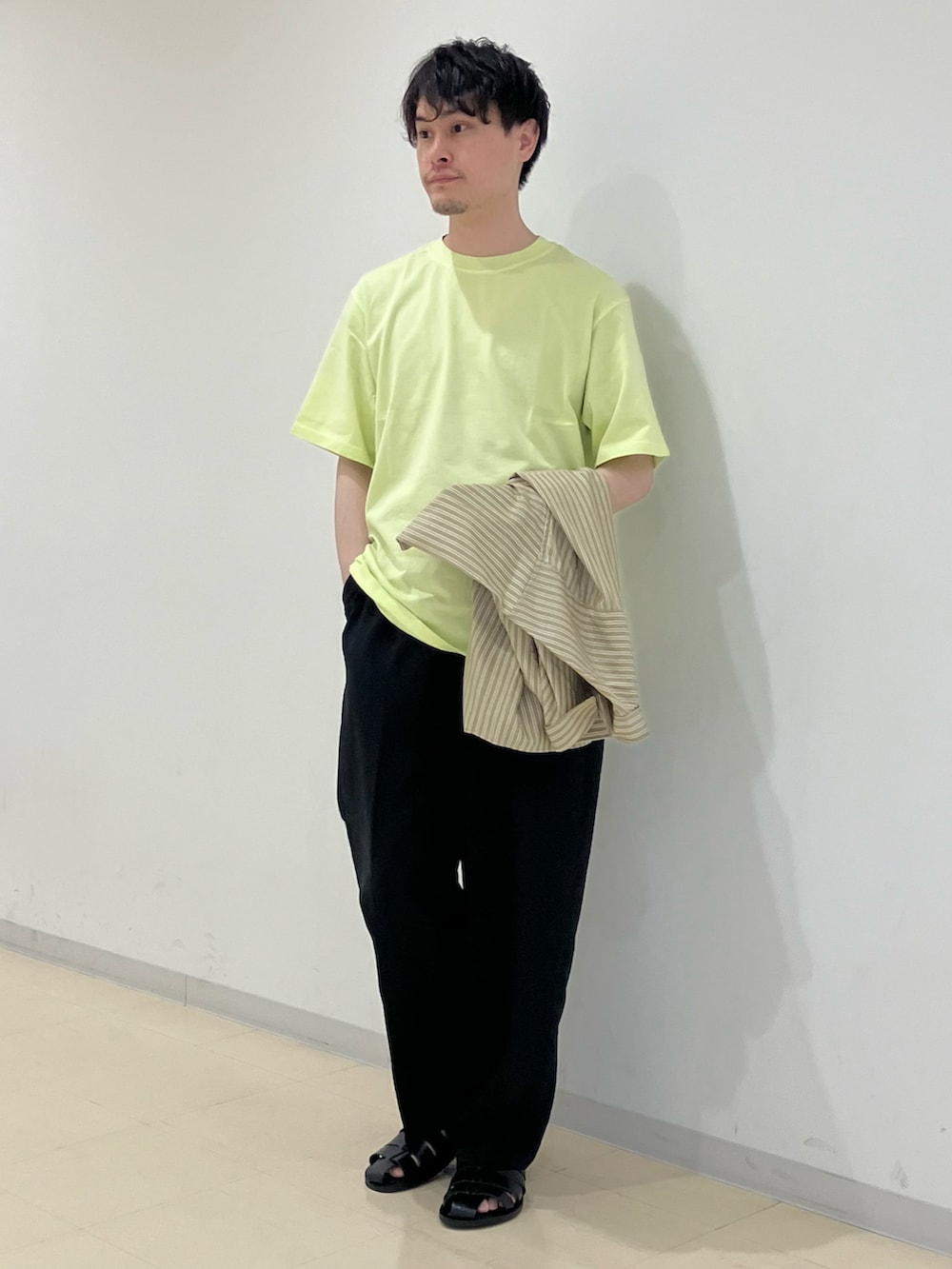 ベージュ系のシャツ/ブラウス、イエロー系のTシャツ/カットソー、ブラック系のスラックスを着用したメンズの春コーディネートの4枚目の写真