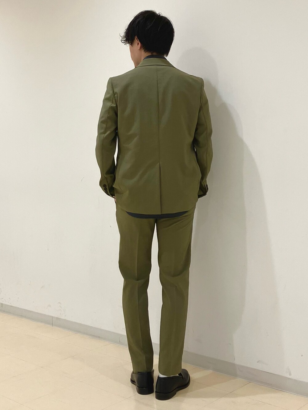 グリーン系のセットアップ、グレー系のシャツ/ブラウス、ブラック系のローファーを着用したメンズの夏コーディネートの3枚目の写真