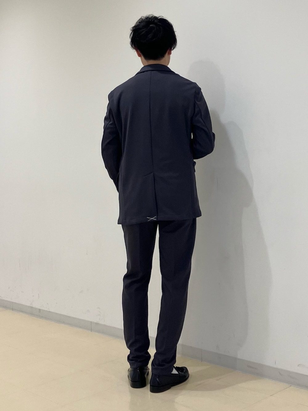 ベージュ系のニット/セーター、グレー系のスーツジャケット、グレー系のスーツパンツを着用したメンズの冬コーディネートの3枚目の写真