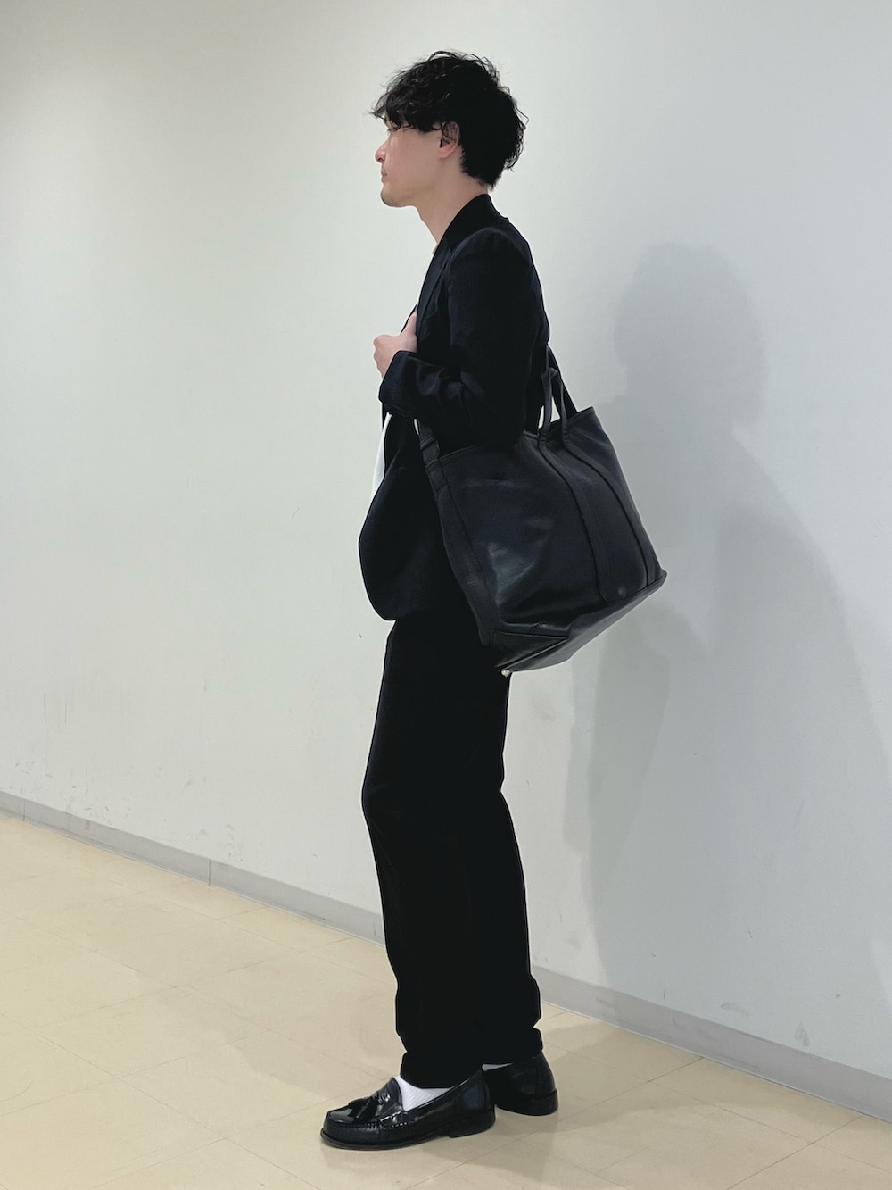 ホワイト系のTシャツ/カットソー、ブルー系のスーツジャケット、ブラック系のトートバッグを着用したメンズの夏コーディネートの4枚目の写真