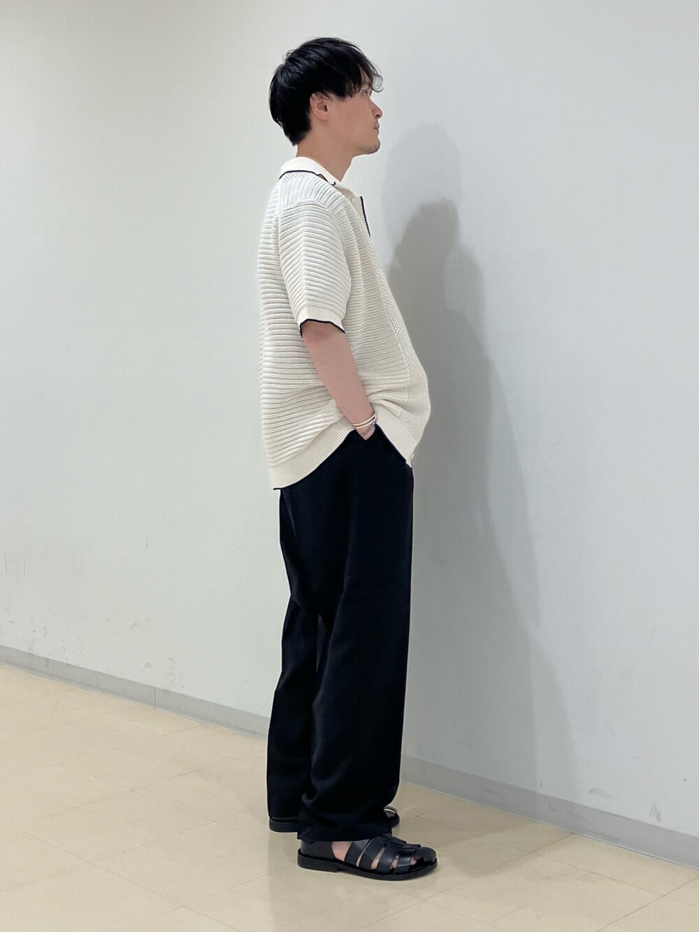 ホワイト系のニット/セーター、その他のTシャツ/カットソー、ブラック系のスラックスを着用したメンズの春コーディネートの2枚目の写真