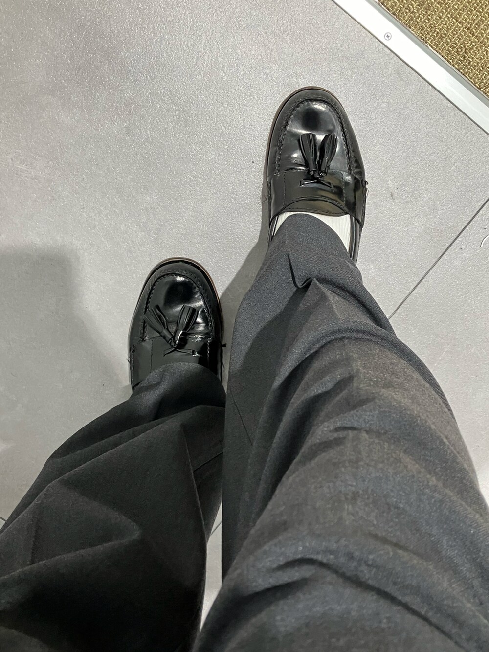 グリーン系のミリタリージャケット、ブラウン系のニット/セーター、グレー系のスラックスを着用したメンズの冬コーディネートの4枚目の写真