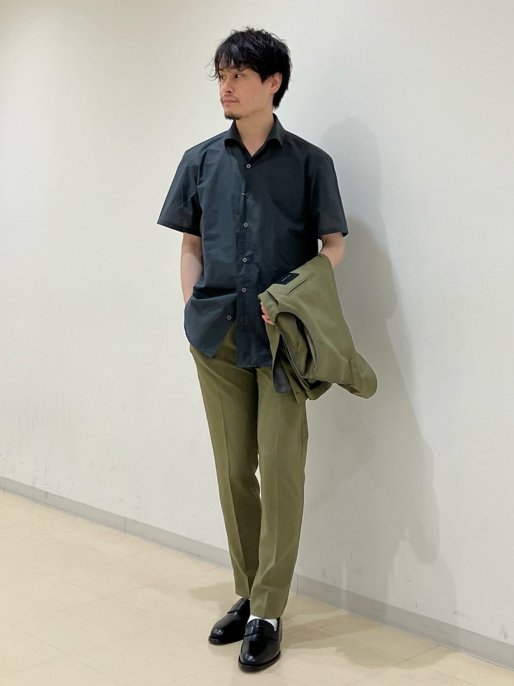 グリーン系のセットアップ、グレー系のシャツ/ブラウス、ブラック系のローファーを着用したメンズの夏コーディネートの4枚目の写真