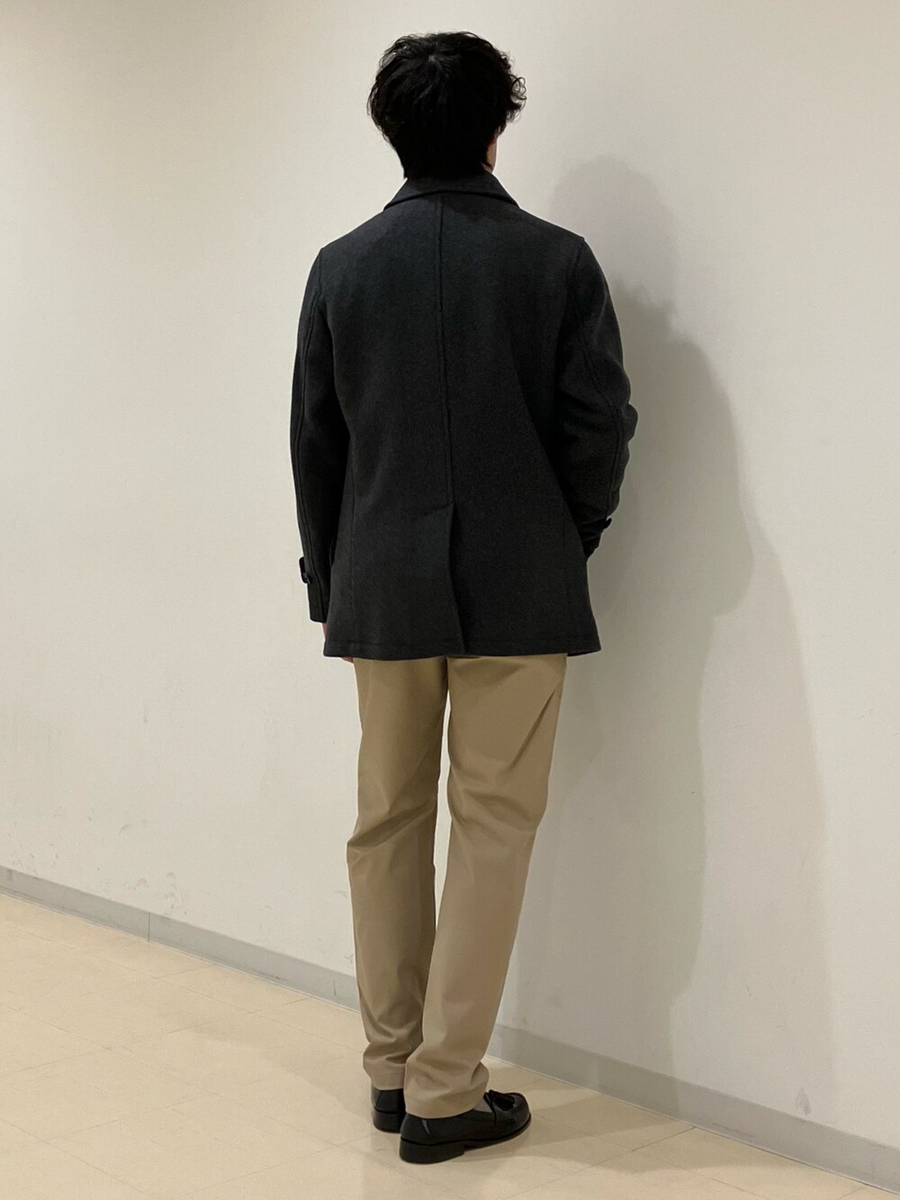 グレー系のピーコート、ホワイト系のニット/セーター、ベージュ系のその他パンツを着用したメンズの冬コーディネートの3枚目の写真