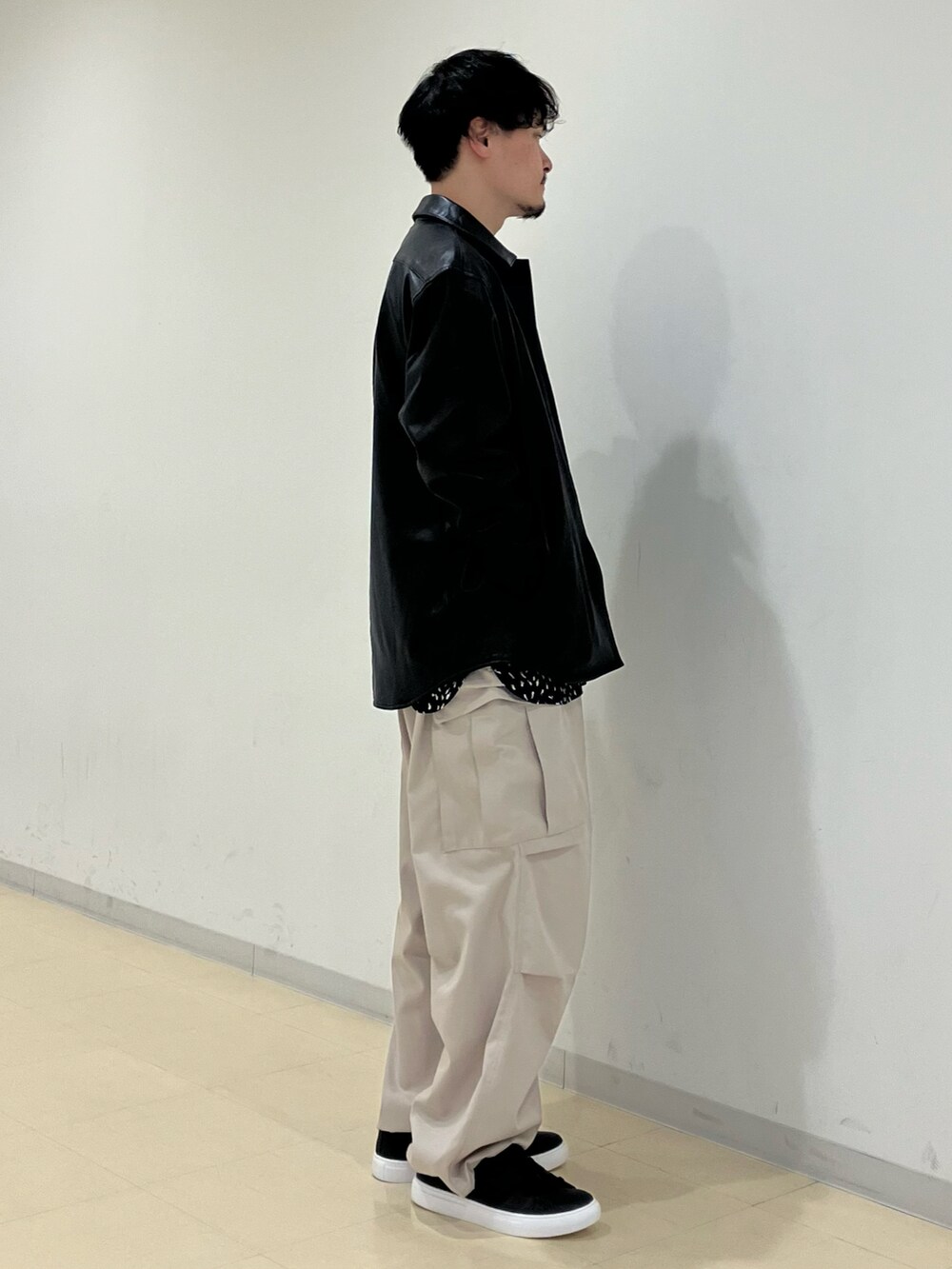ブラック系のブルゾン、ブルー系のシャツ/ブラウス、ベージュ系のカーゴパンツを着用したメンズの春コーディネートの2枚目の写真