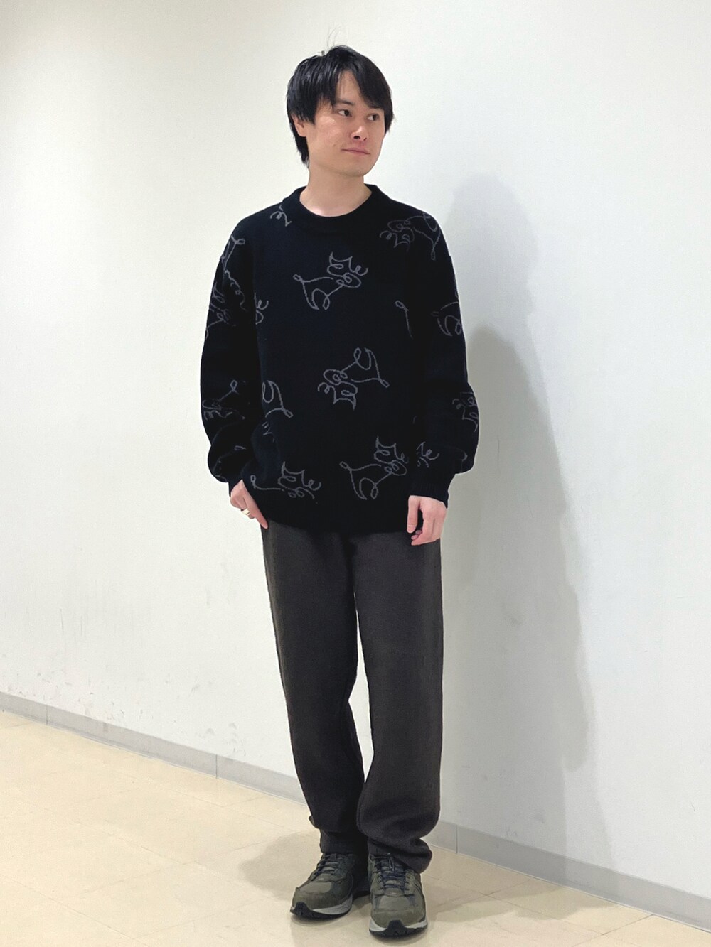 ブラウン系のブルゾン、ブラック系のニット/セーター、グリーン系のスラックスを着用したメンズの秋コーディネートの3枚目の写真