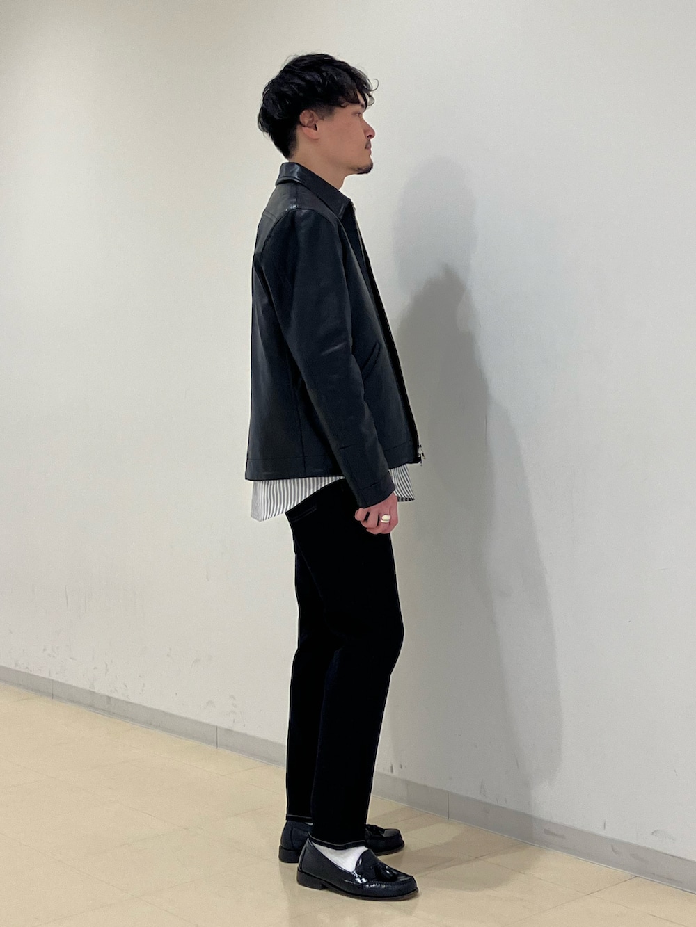 グレー系のシャツ/ブラウス、ブラック系のブルゾン、ブルー系のデニムパンツを着用したメンズの冬コーディネートの2枚目の写真