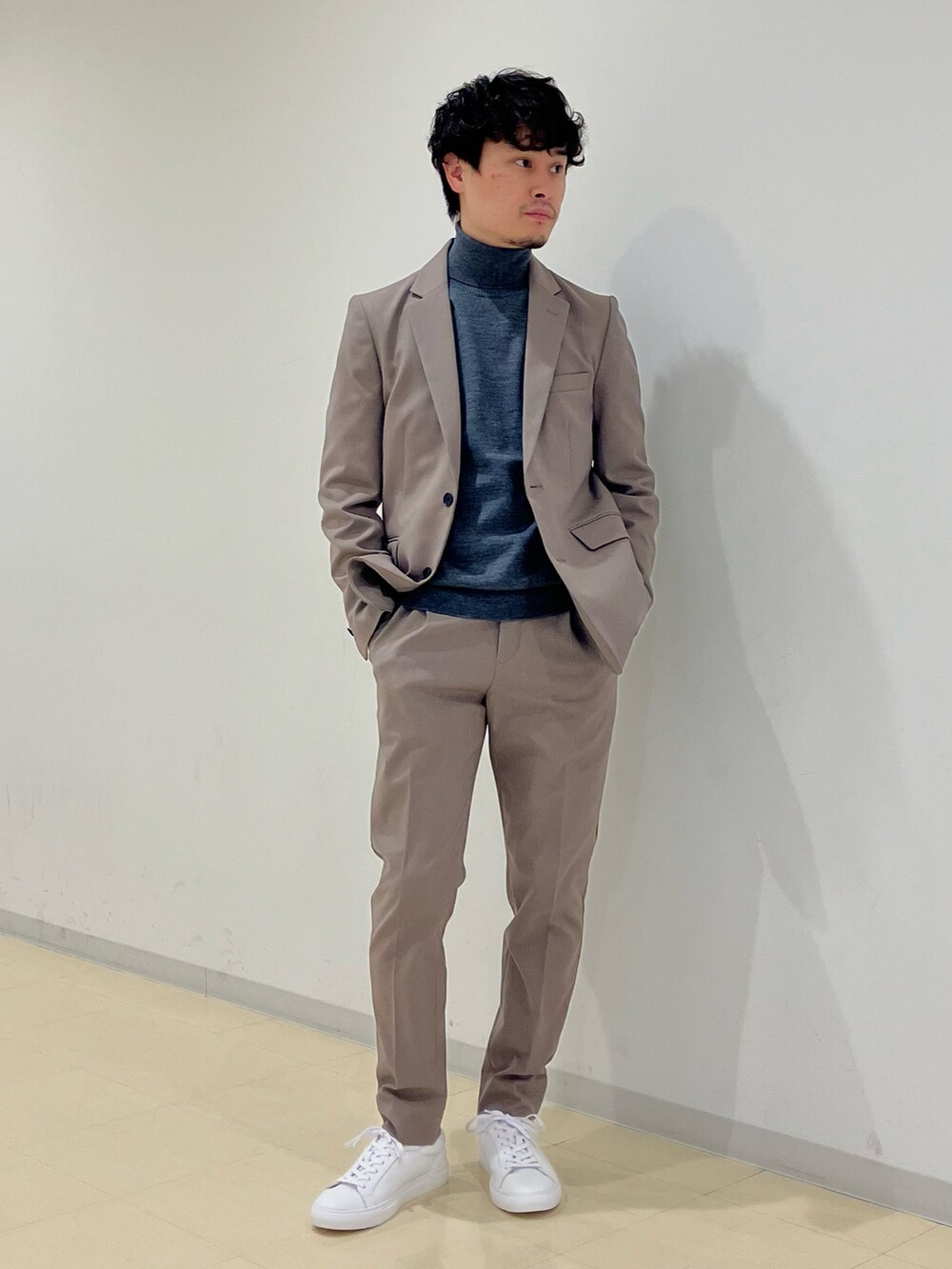 グレー系のニット/セーター、ブラック系のダウンジャケット/コート、ベージュ系のセットアップを着用したメンズの冬コーディネートの4枚目の写真