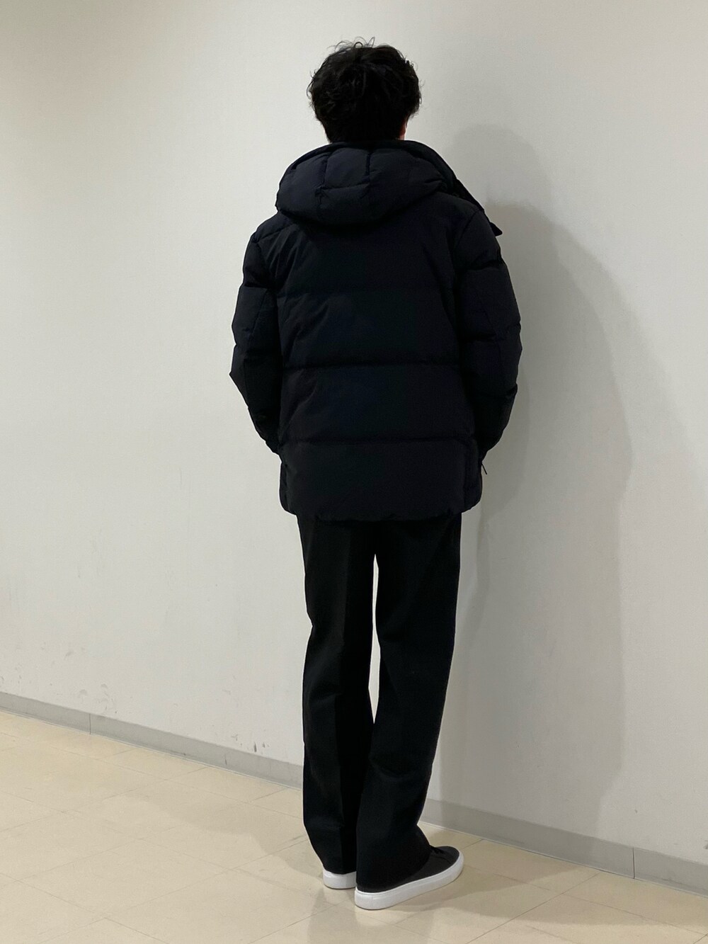 ホワイト系のニット/セーター、ブラック系のダウンジャケット/コート、ブラック系のその他パンツを着用したメンズの冬コーディネートの3枚目の写真