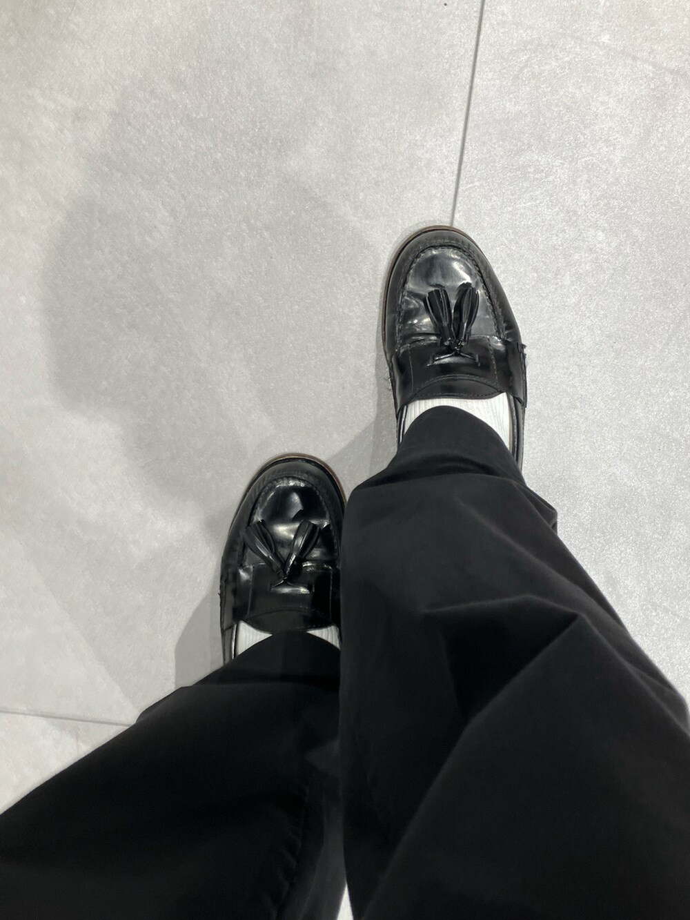 ブラック系のスーツジャケット、ブラック系のパンツ、ブラック系のローファーを着用したメンズの冬コーディネートの2枚目の写真